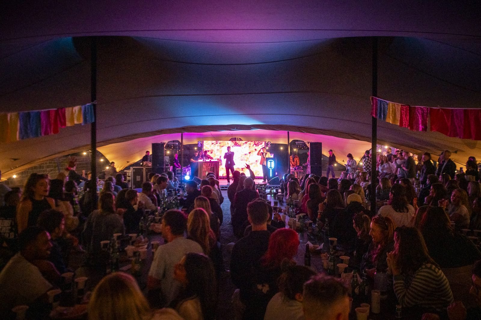 Crowd watching a live set inside a large stretch tent at the Unite festival, Eastnor Castle