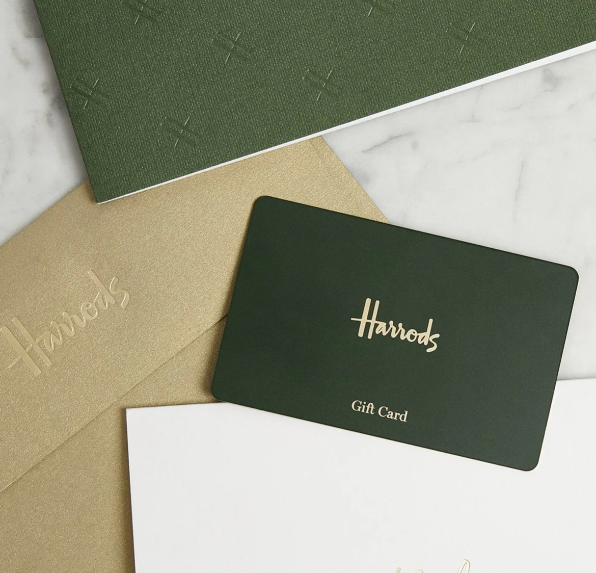 Harrods gift card on white background, with green, gold, and white textured paper around it.