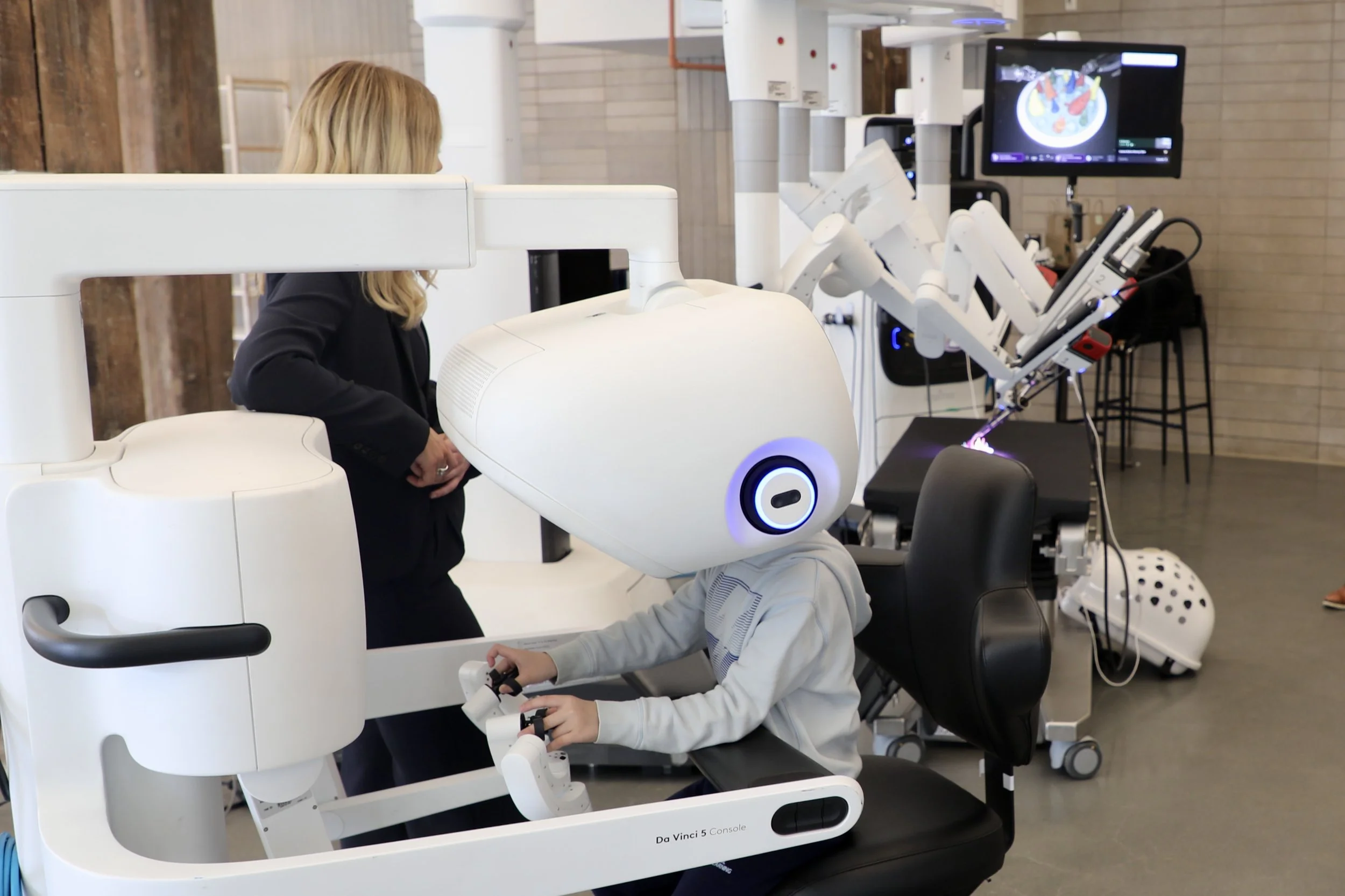 A child operates the demonstration surgical robot.jpeg