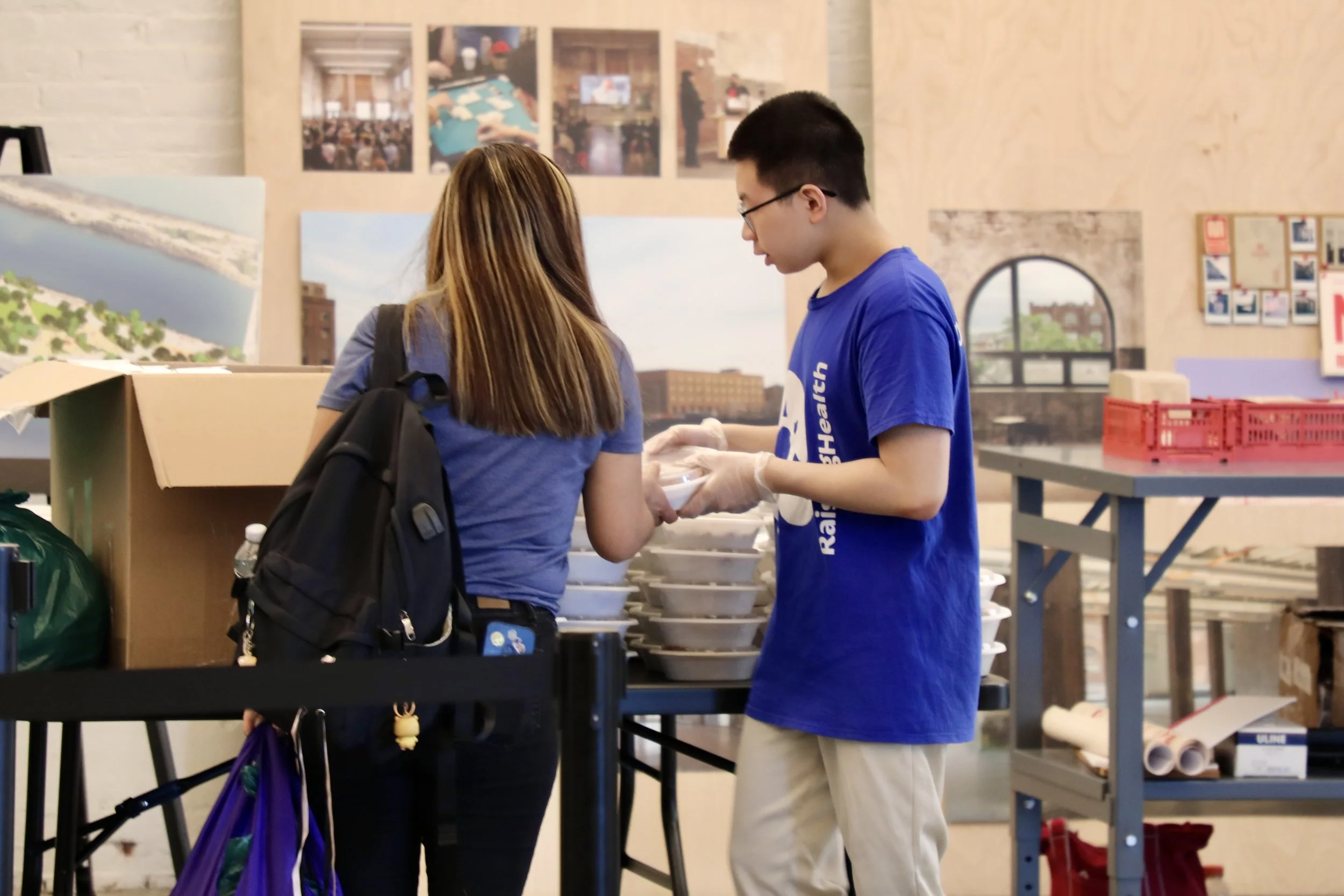 RaisingHealth volunteer hands attendee a hot meal.jpeg