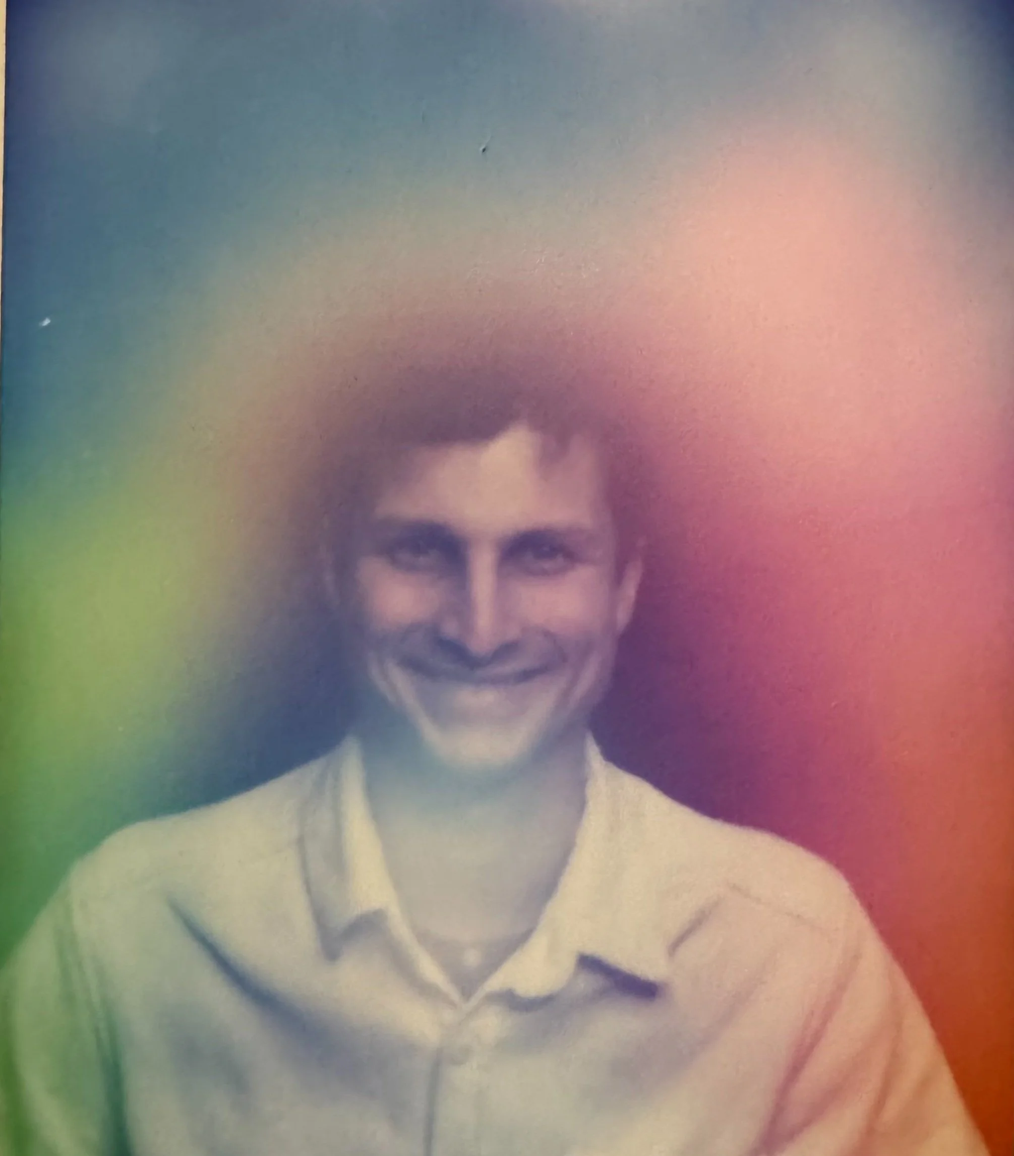Person smiling with colorful aura surrounding their head.