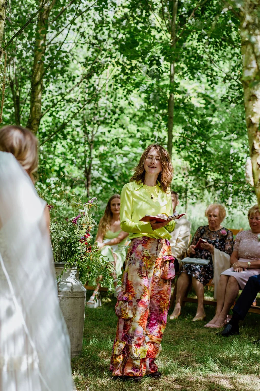 Best friend of the bride reads during the woodland ceremony in devon