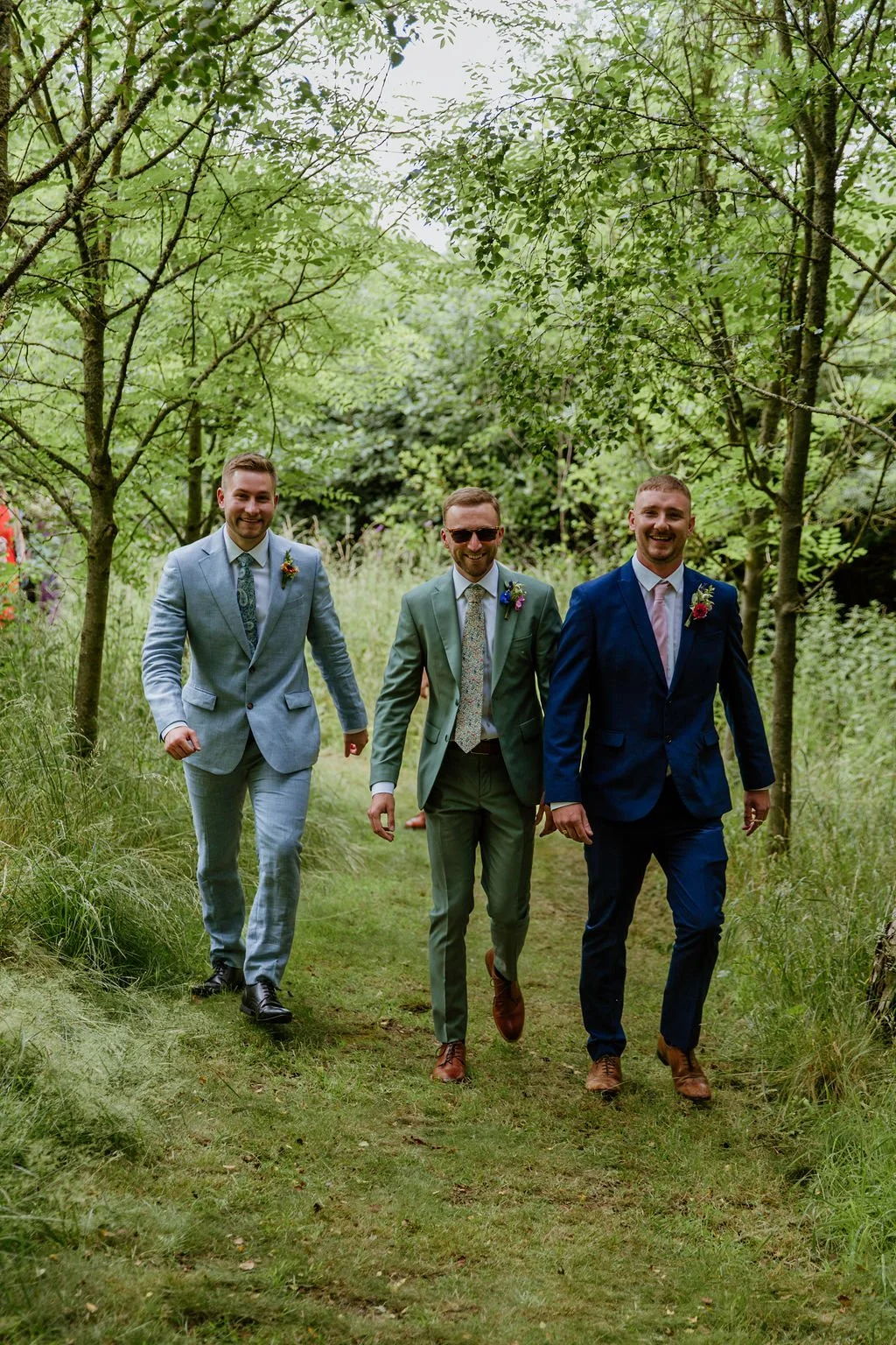 Groom and his groomsmen walking through the woods to the ceremony at Higher Holcombe