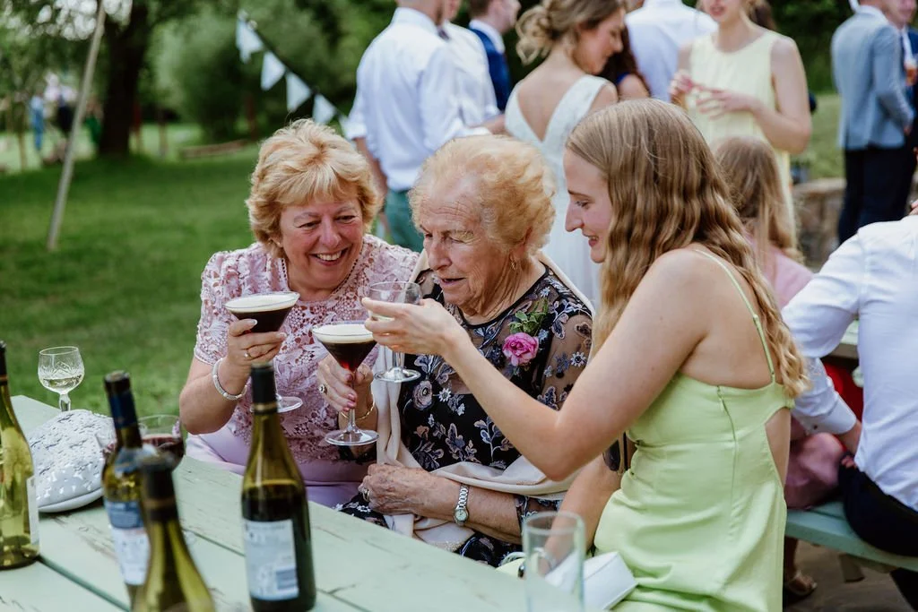 Three generations of women enjoy espresso martinis at golden hour