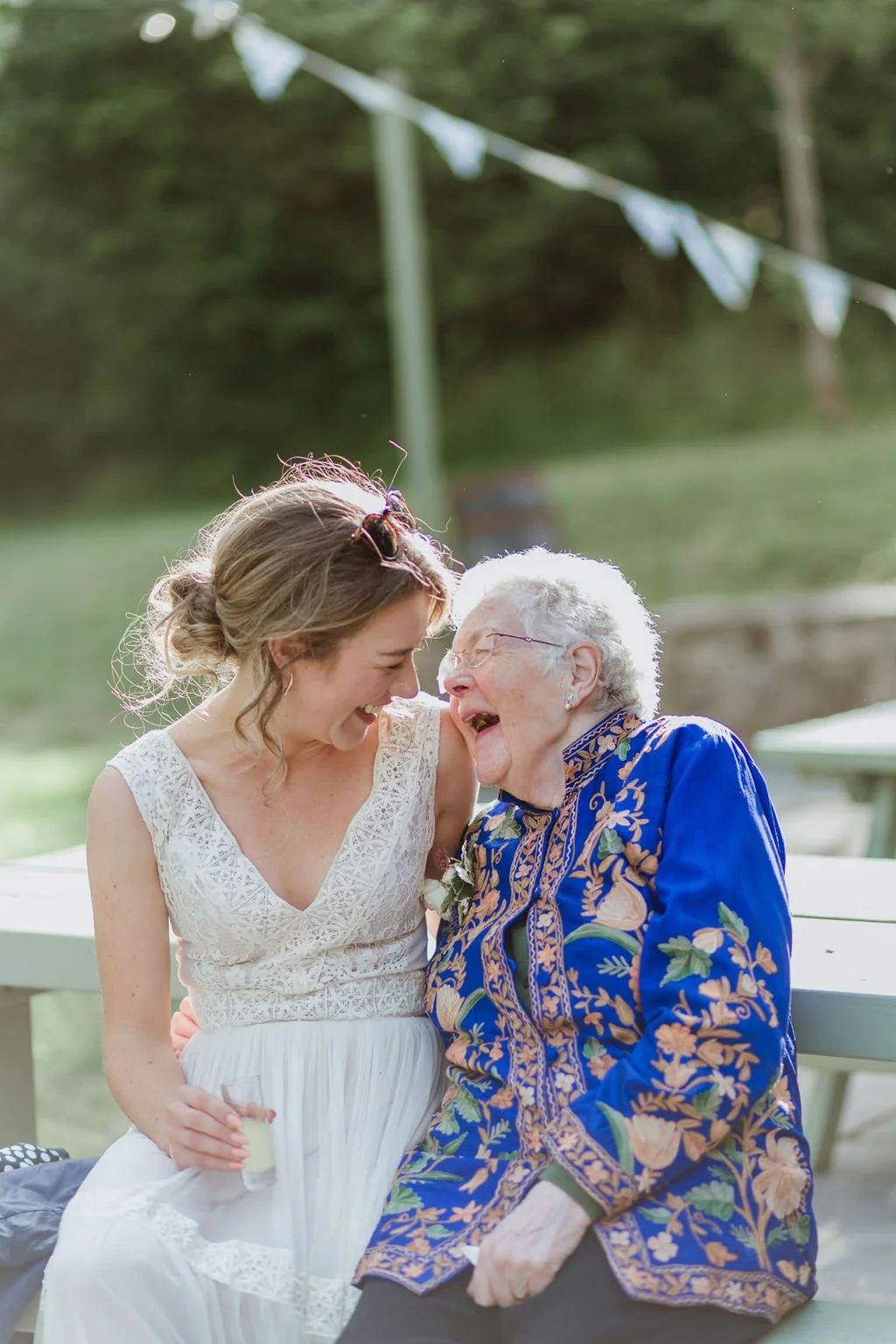 bride and grandmother laughing in the golden hour light