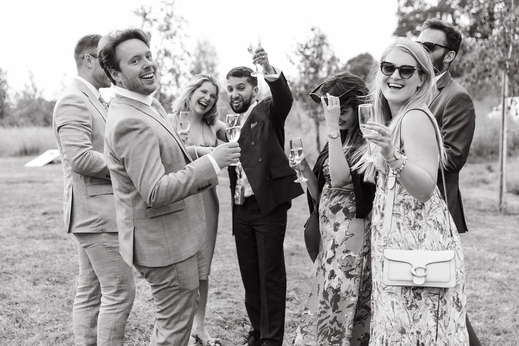 group of guests cheers and smile candidly at the camera