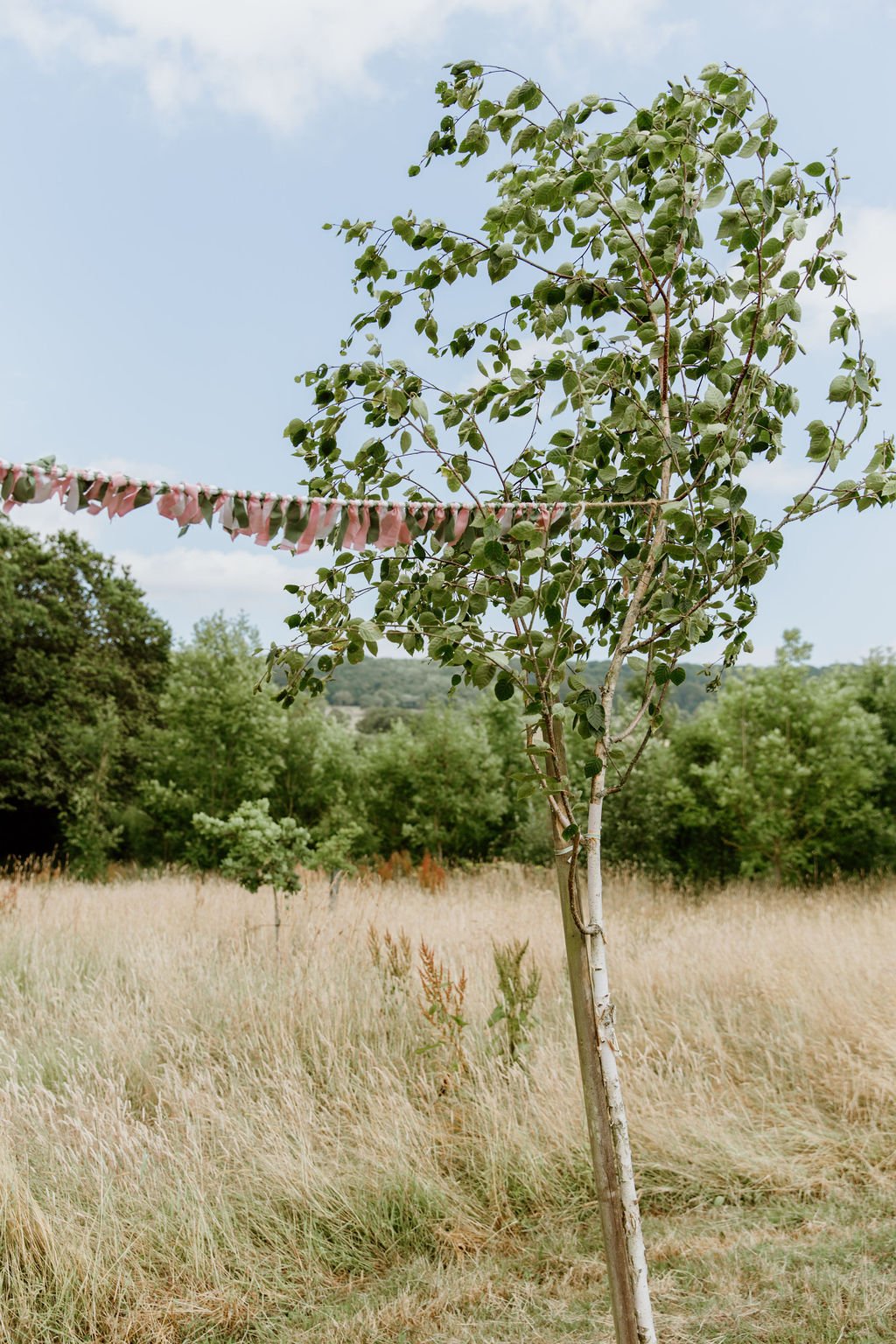 colourful fabric bunting blowing in the breeze outside at wedding venue
