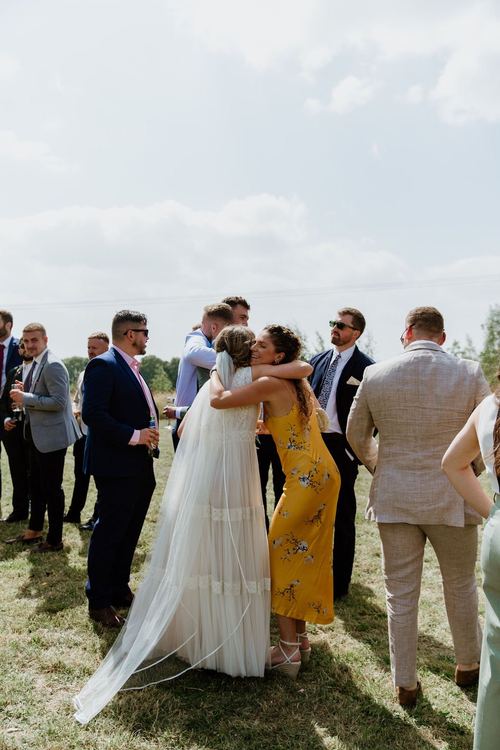 bride hugs guest in a yellow dress