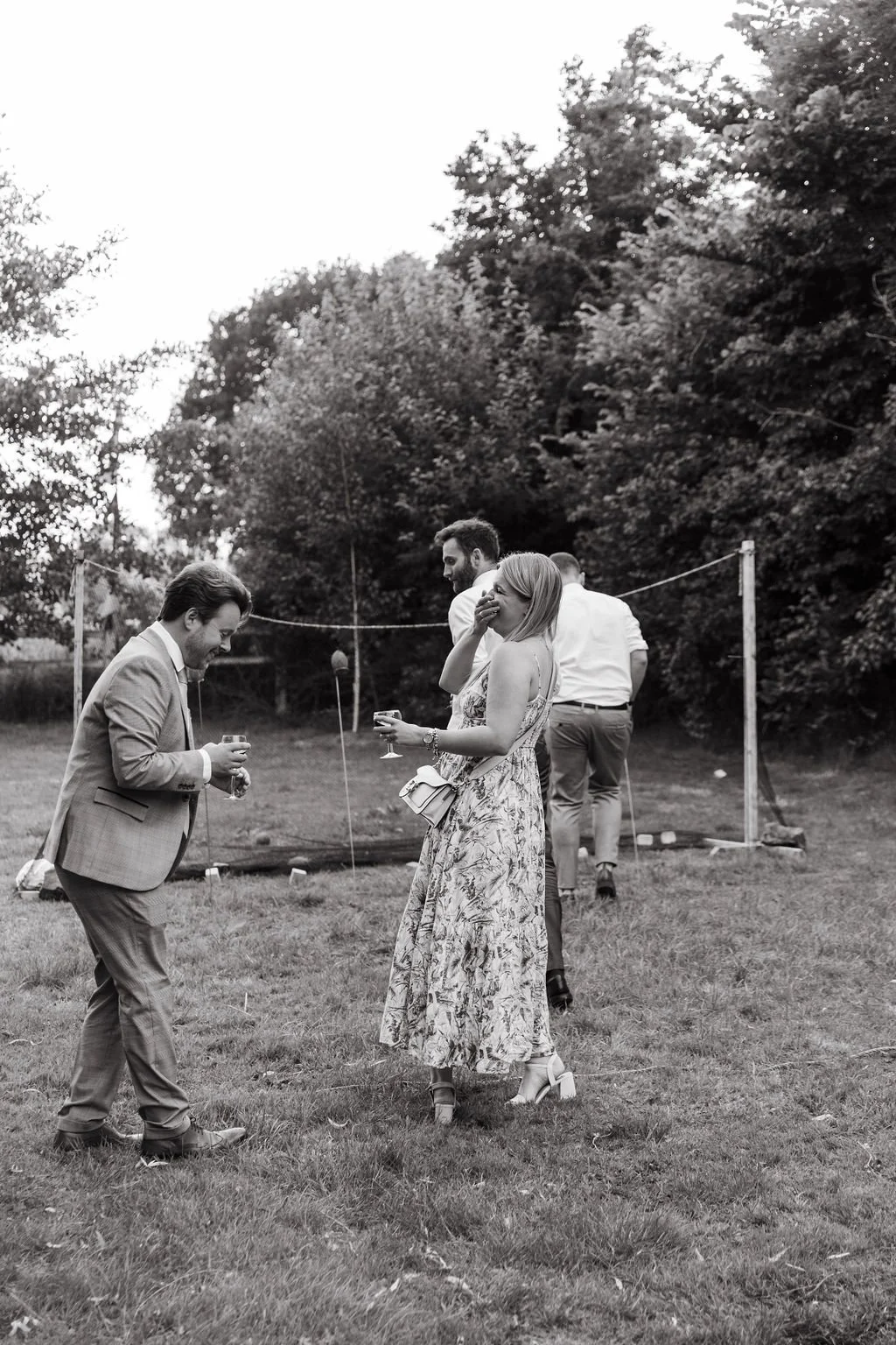 wedding guests laugh while playing outdoor garden games at wedding