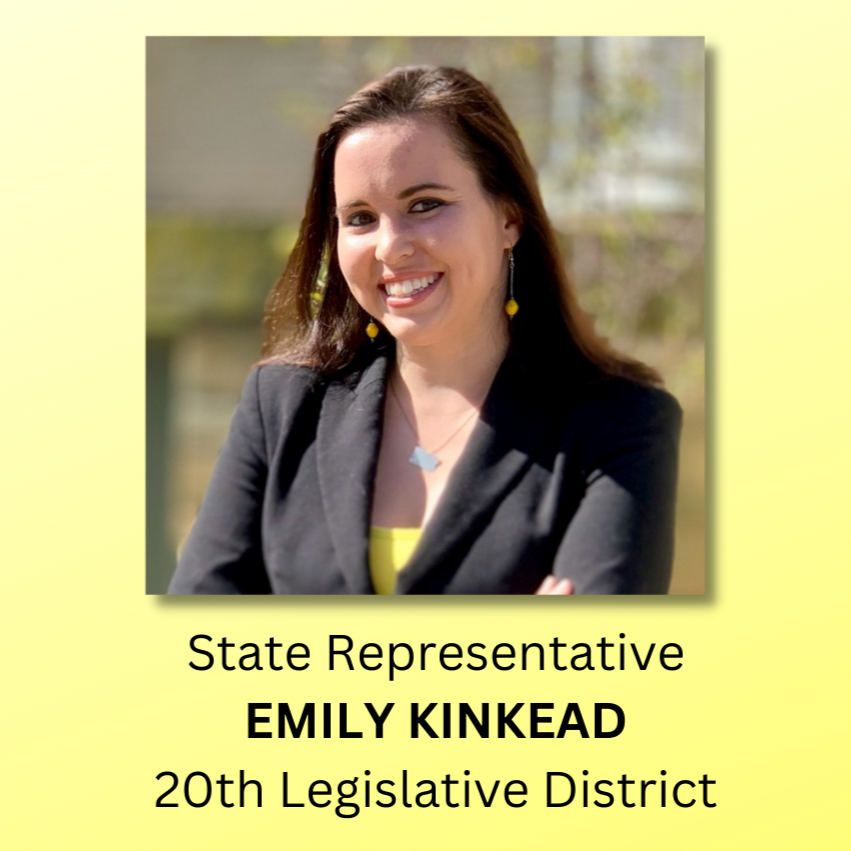 Headshot of Emily Kinkead, a woman with long brown hair smiles and wears a yellow shirt and earrings with a black blazer