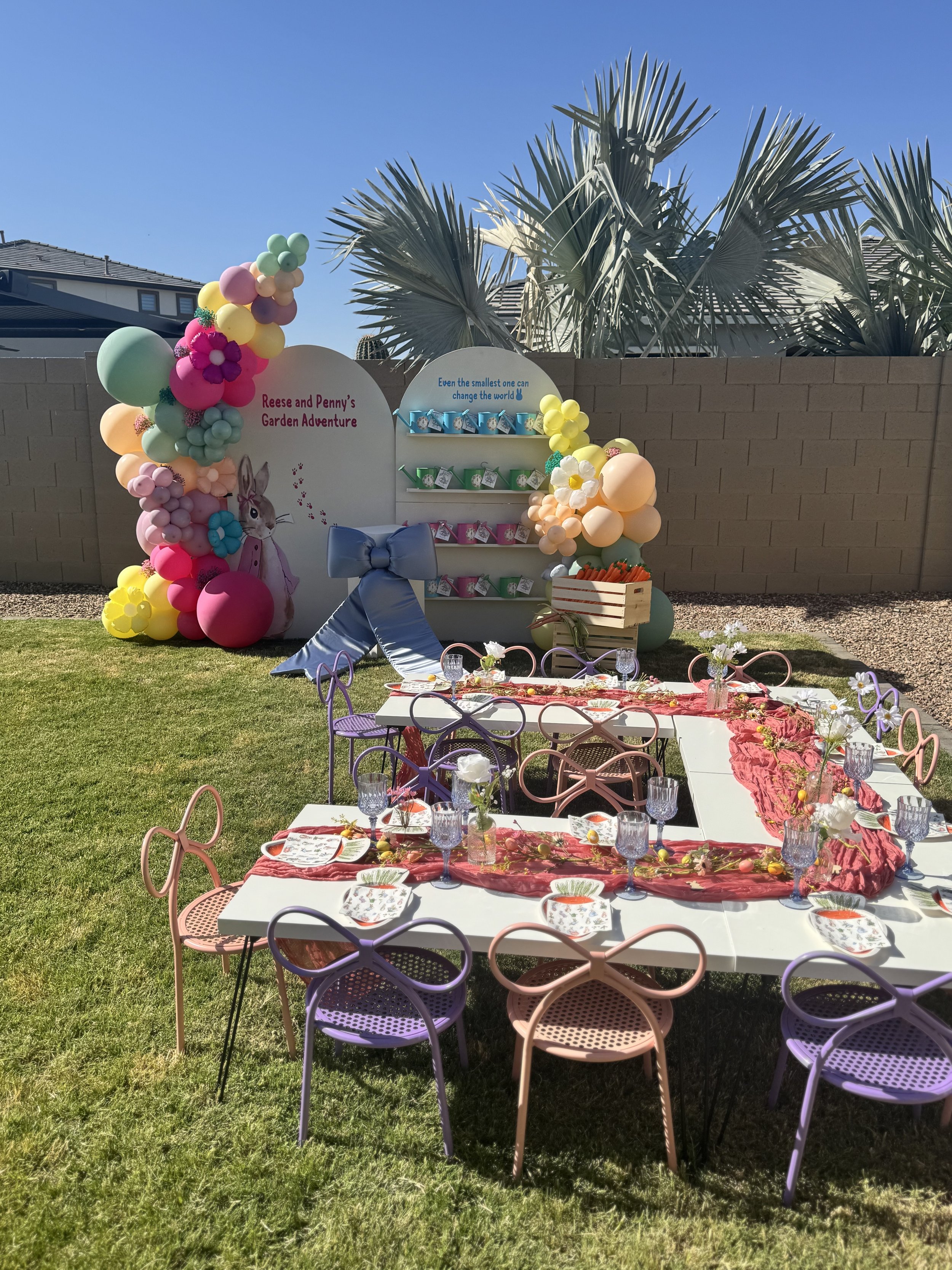 Kids table setup with balloon arch, custom cake topper, and centerpieces