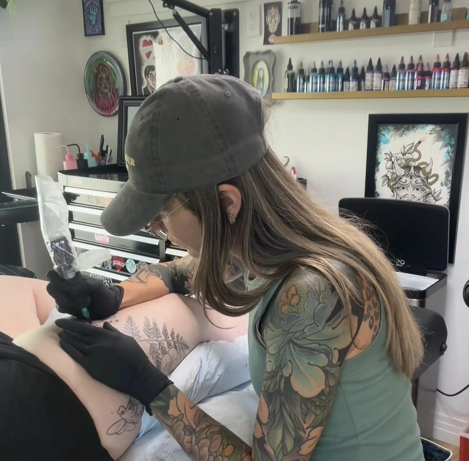 tattoo artist tattooing client arm