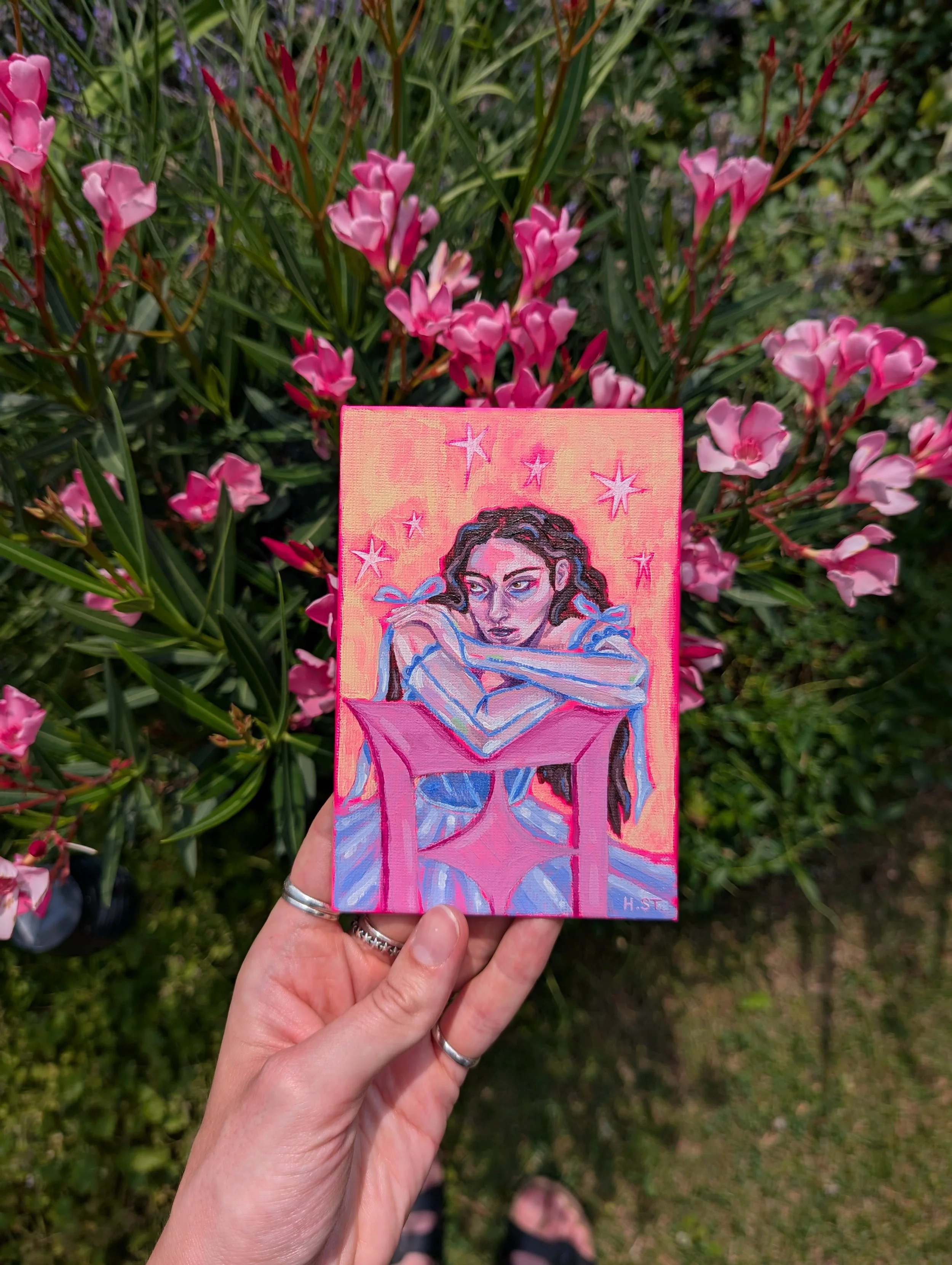 Portraitmalerei einer Frau mit nachdenklichem Blick, die sich über einen rosa Stuhl lehnt. Die Frau trägt ein lila blaues Tüllkleid und ist von Sternen und einem knallig gelben und pinken Hintergrund umgeben. Künstlerin Hannah Stollenwerk, Acryl