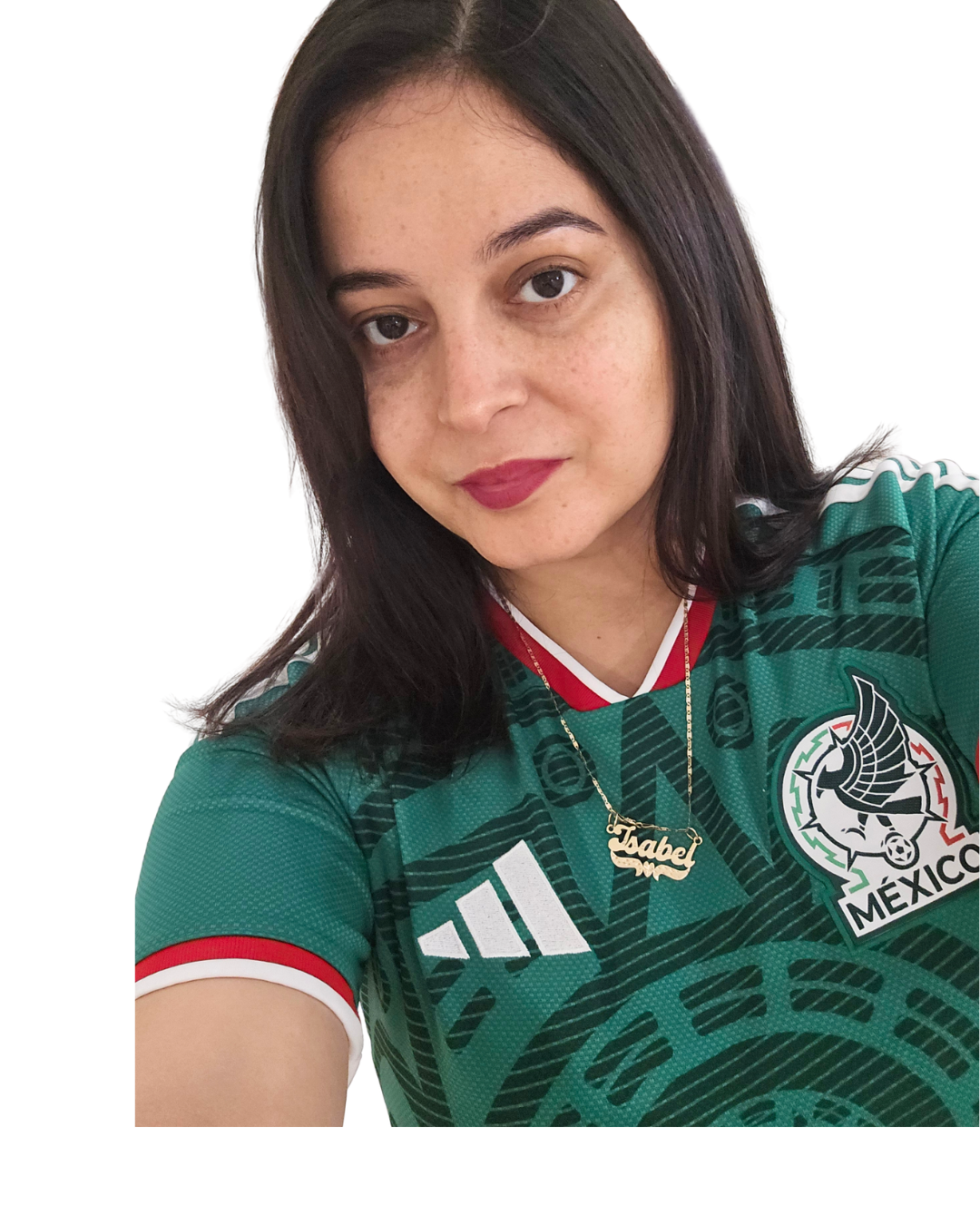 A woman taking a selfie, wearing a green Mexico national soccer team jersey with the Mexican soccer crest, Adidas logo, and red and white accents. She has long dark hair, freckles, and is wearing a gold necklace with a name pendant.