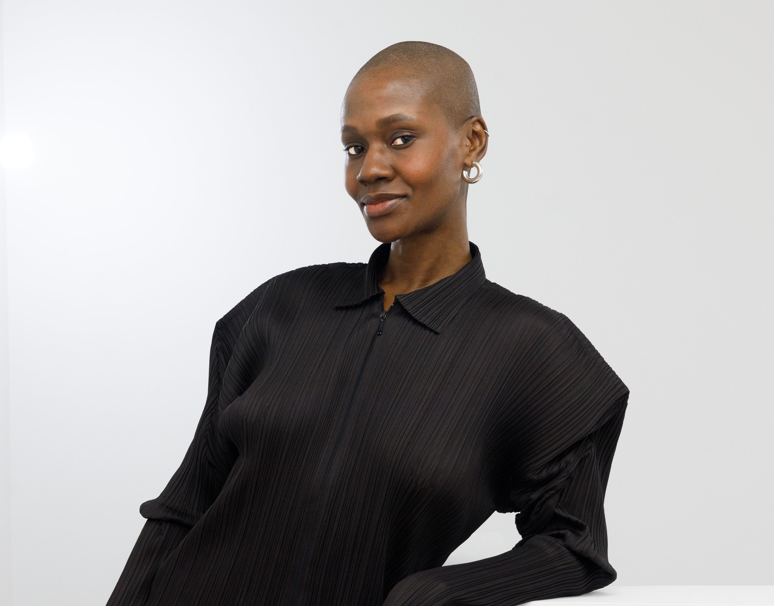 Photo de Yolonda Abrahams est directrice chez Cooper Cole, portant un haut noir et le regard fixe