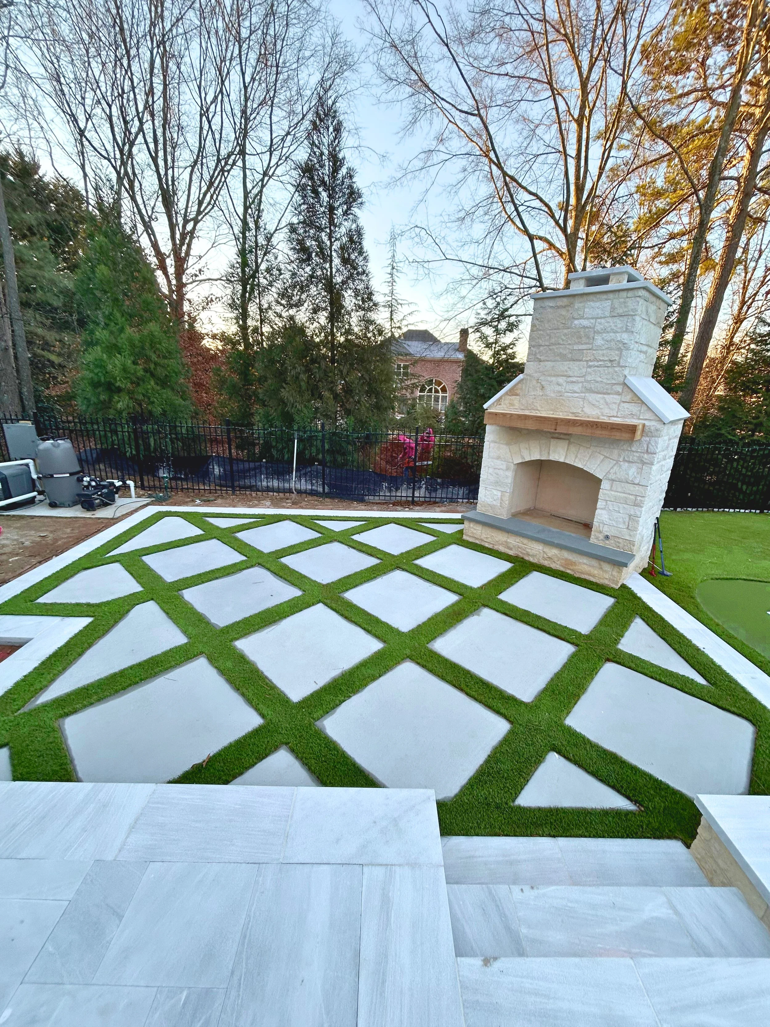 Concrete block patio with grass in a diamond placement.