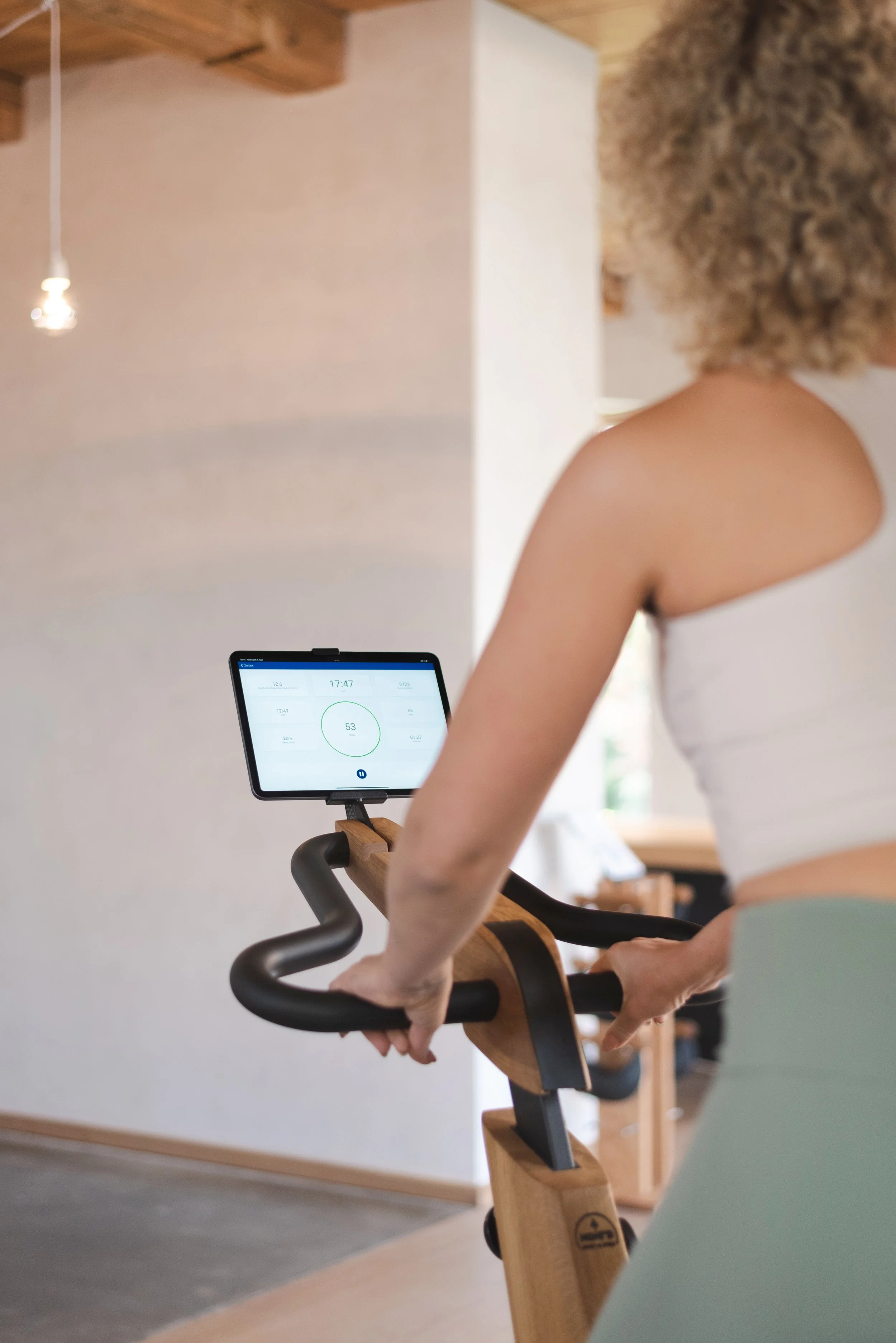 Frau auf Heimtrainer, Blick auf Bildschirm