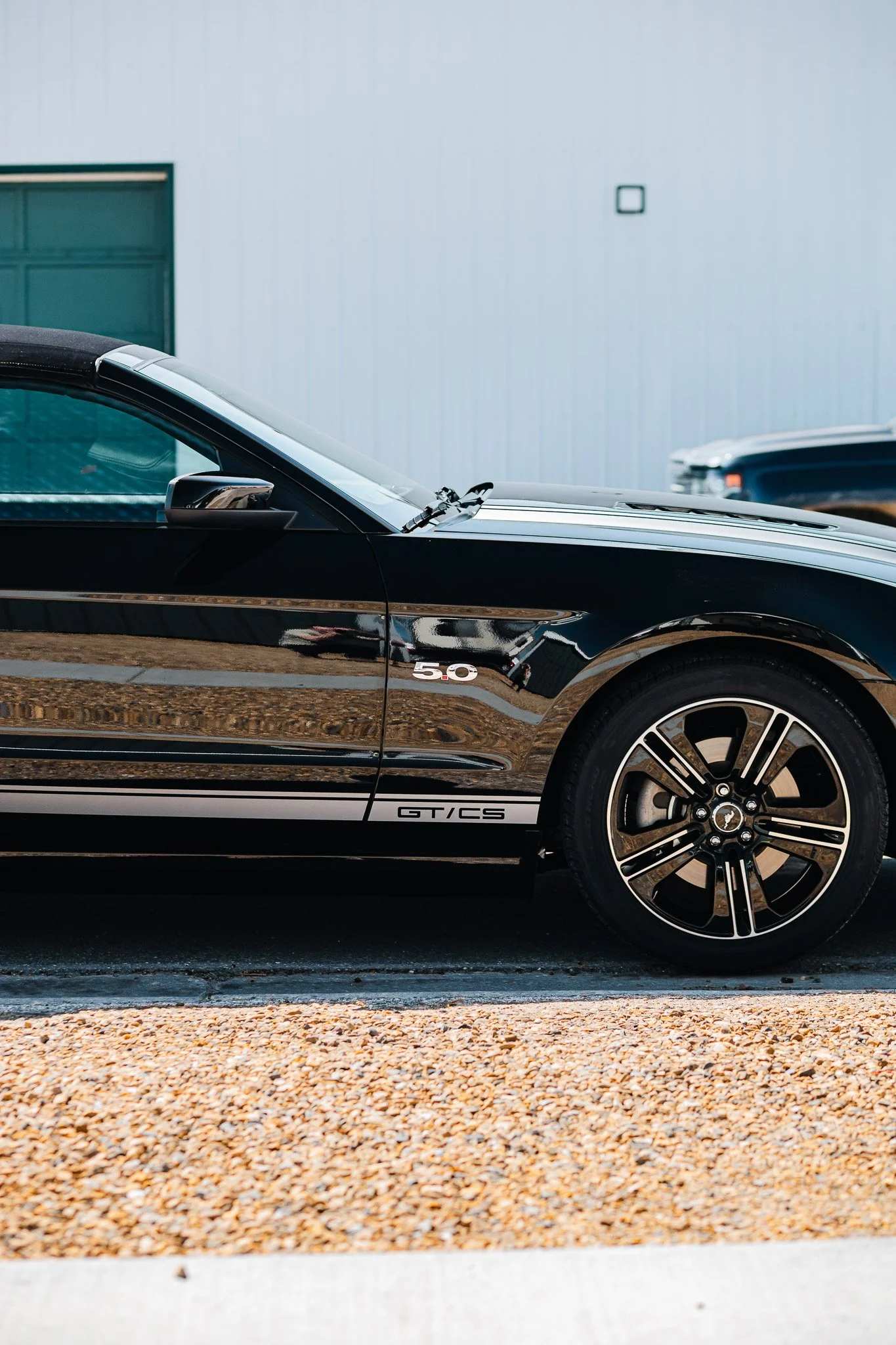 Close-up of a black Ford Mustang with paint protection film and ceramic coating parked on the street in Hanna, Alberta.