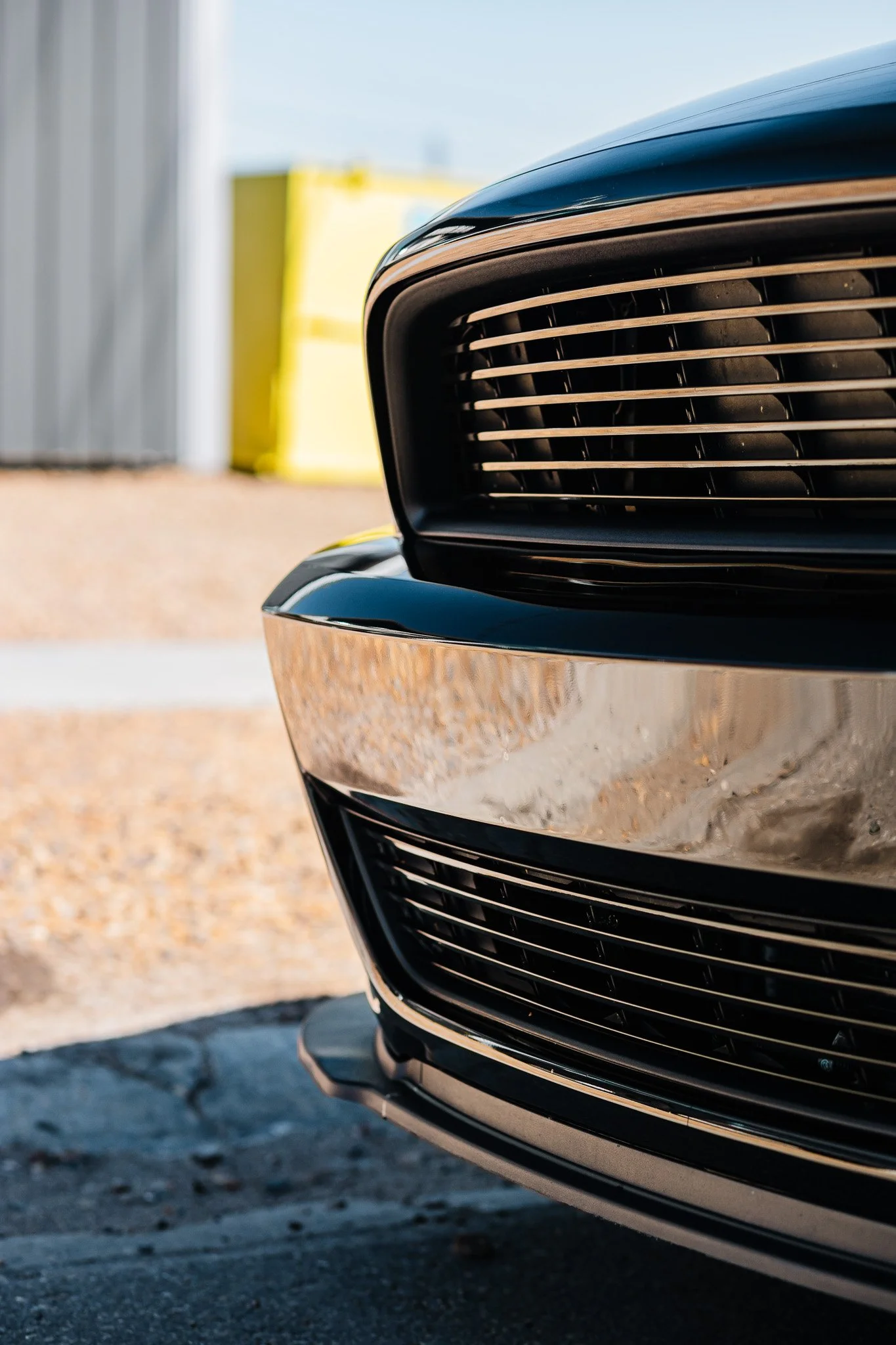 Close-up of the front grille of a black Ford Mustang with paint protection film and ceramic coating parked on the street in Hanna, Alberta.