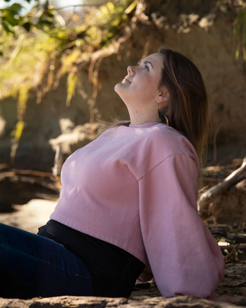 Marisa, body image coach, smiling at the camera while walking among trees outdoors