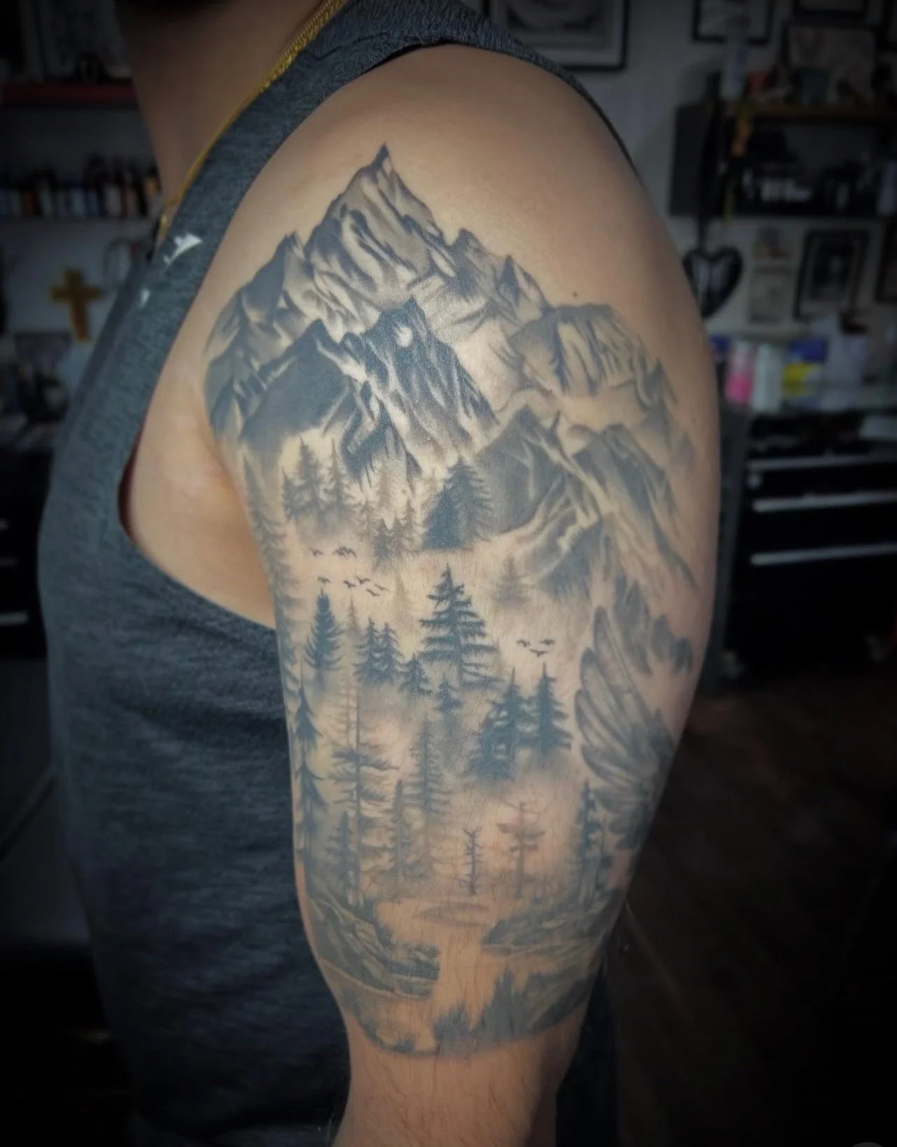 A realism black and grey half sleeve tattoo of a mountain scene with trees and mountains by portland tattoo artist at Upper Moon Tattoo, Daniel Aispuro 
