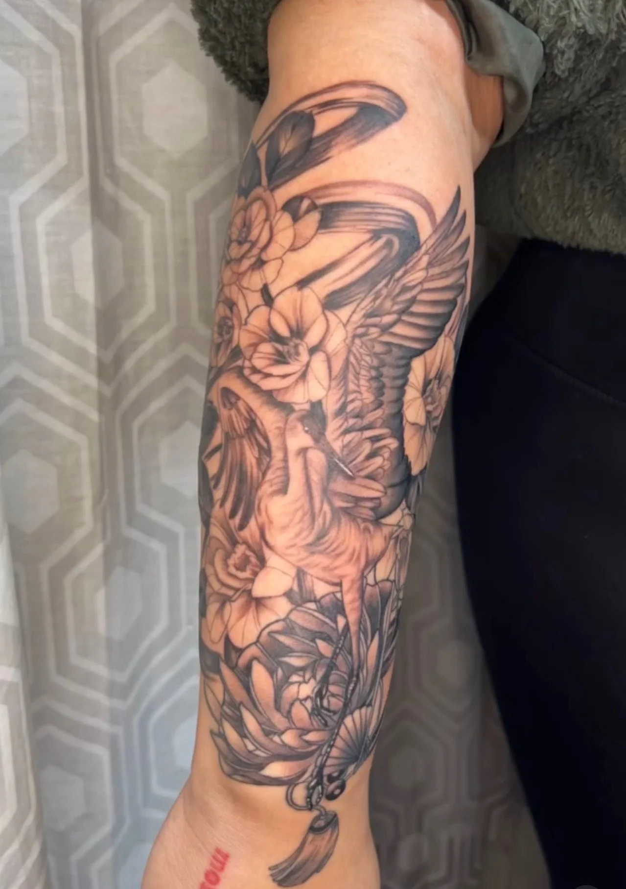 A black and grey realism tattoo on the forearm of a crane and florals by portland tattoo artist at Upper Moon Tattoo, Daniel Aispuro