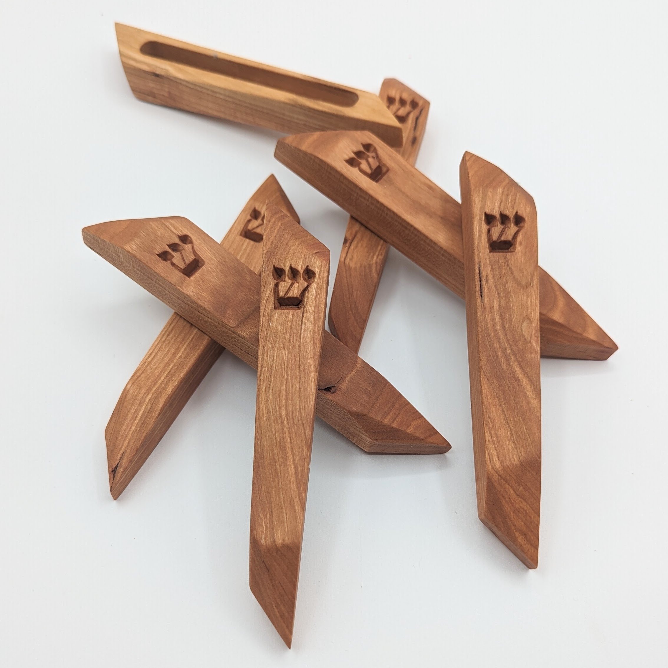 Wooden knitting needle holders with crown-shaped engravings on a white background.