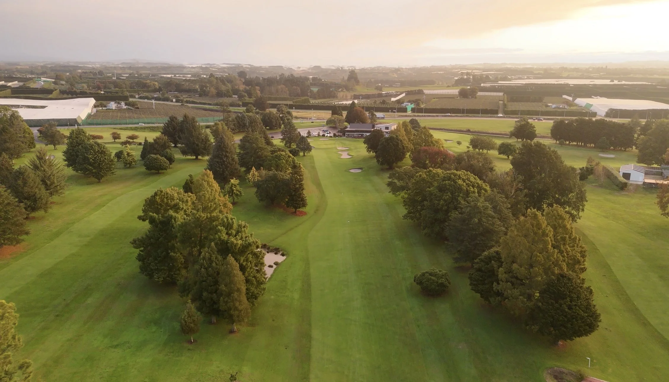Looking down the 18th fairway at Te Puke colf course with the green and clubhouse in the background.