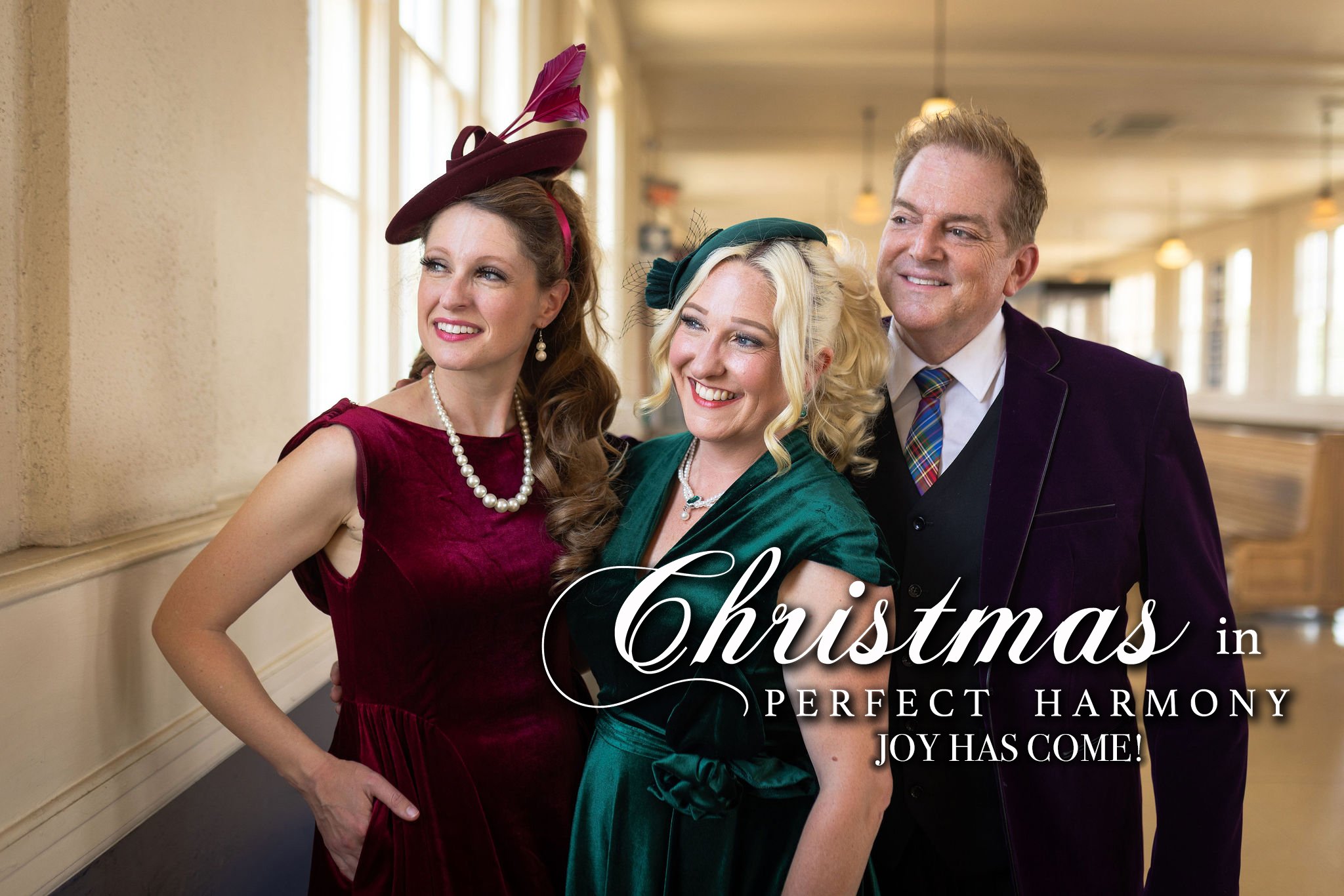 Two women and one man in festive attire smiling.