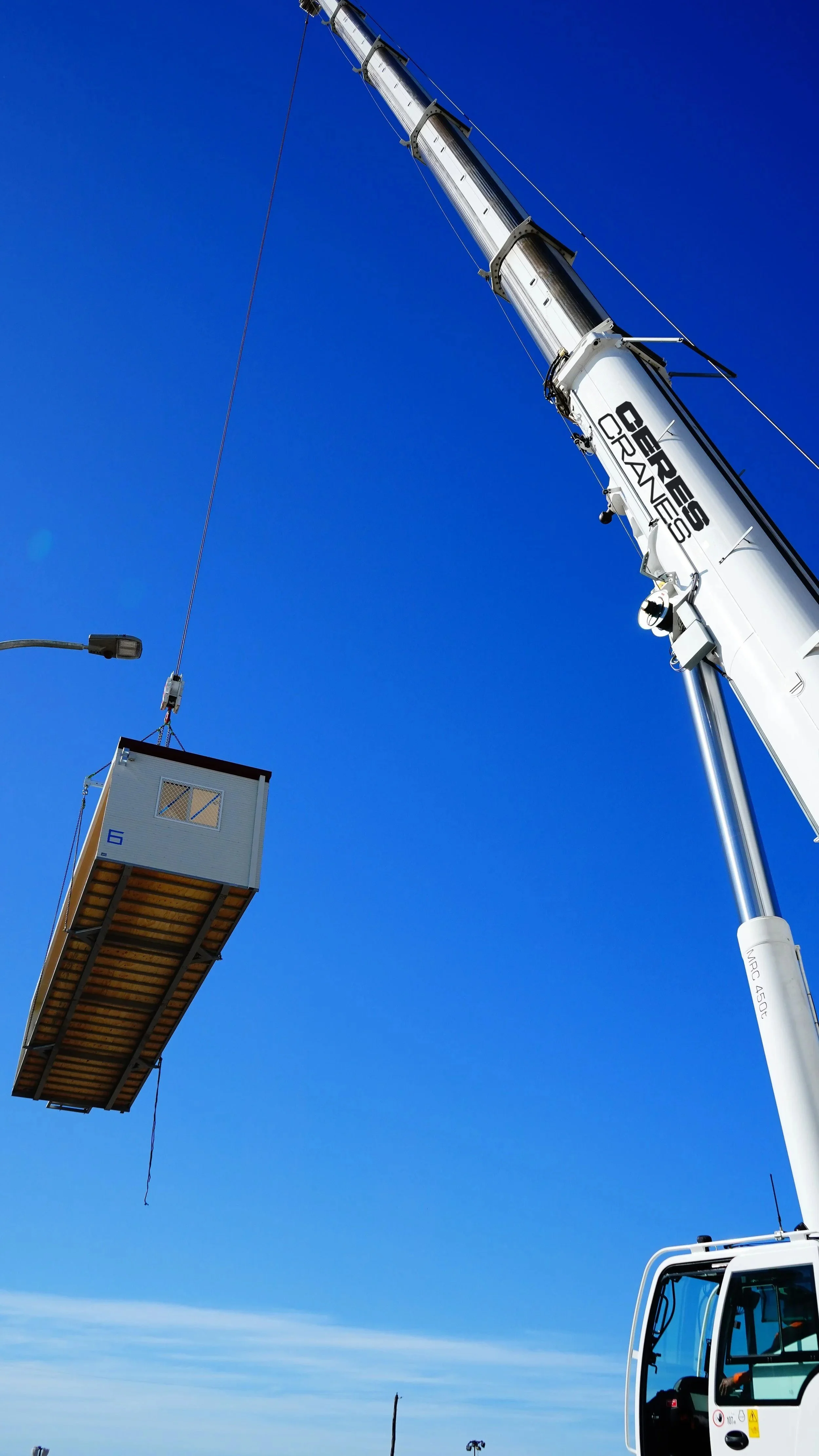 Crane lifting a large load against a blue sky