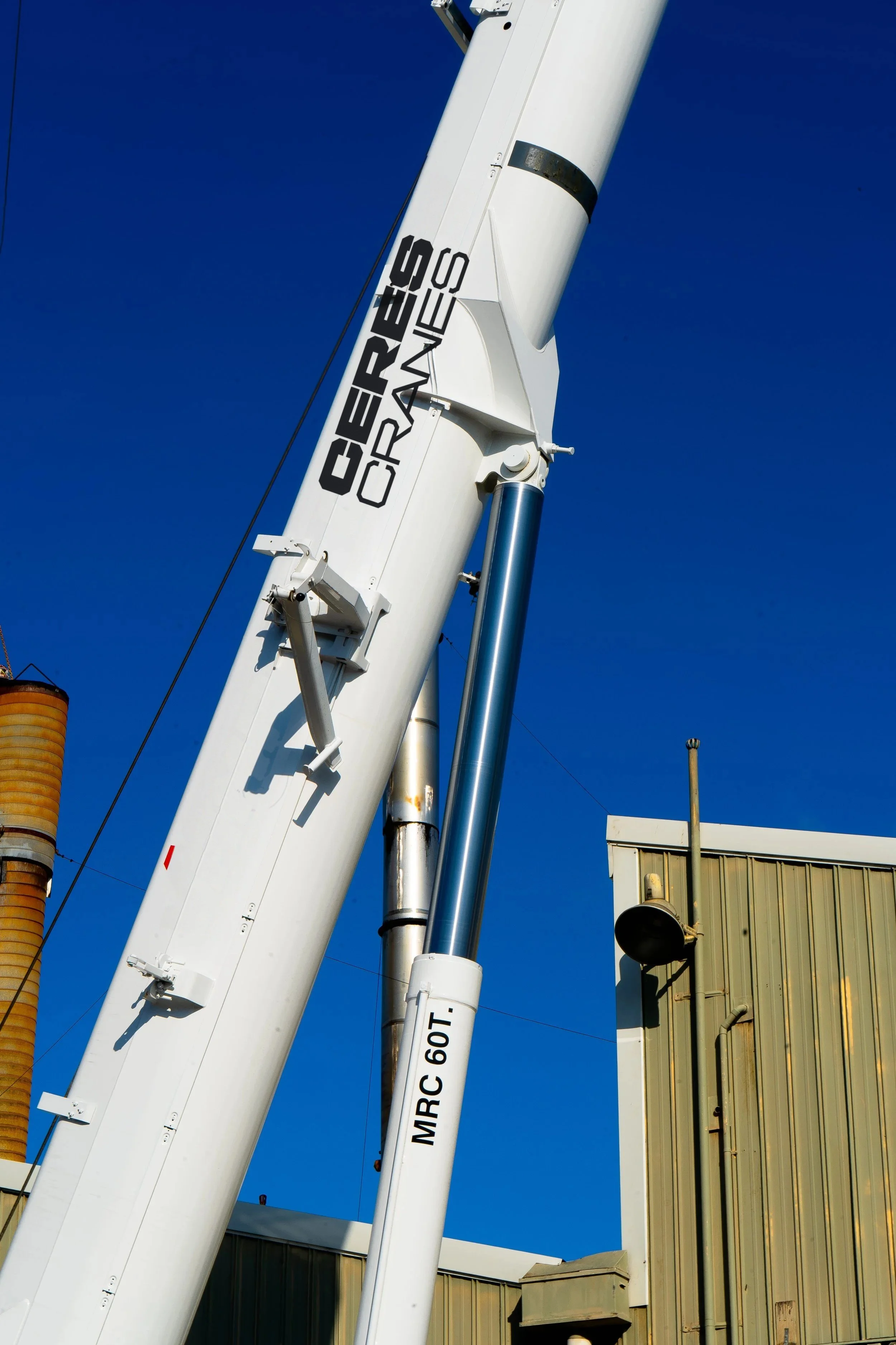 Ceres Cranes lettering on a crane boom beside a factory