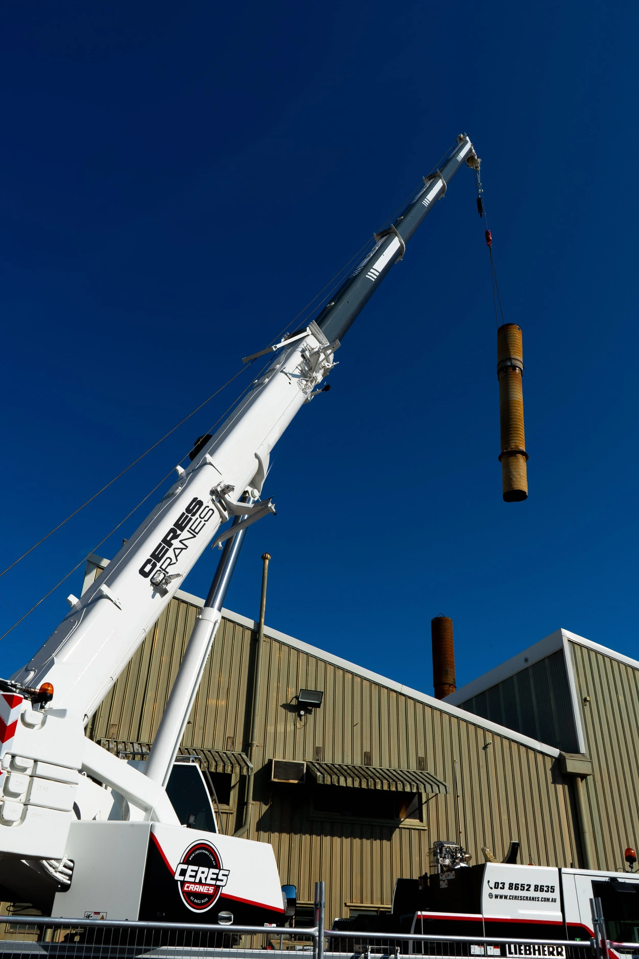 Ceres Cranes 60T Liebherr lifting a steel column beside a factory