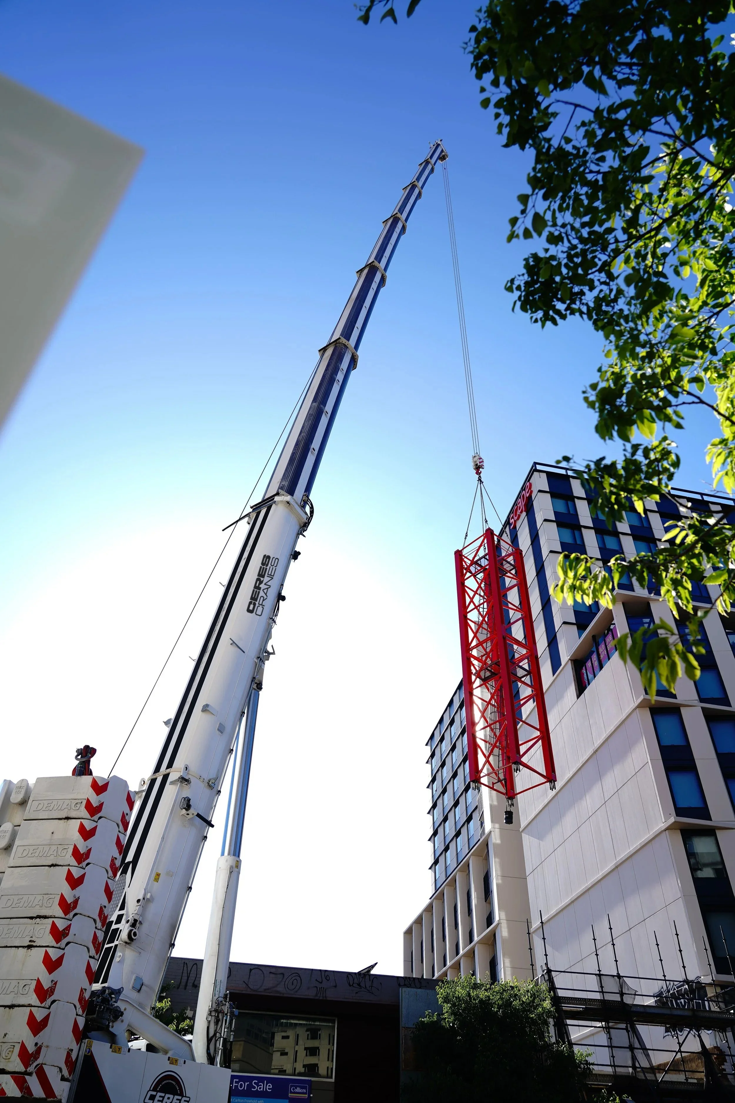 Ceres Cranes 450T Tadano Demag with boom extended beside a high-rise