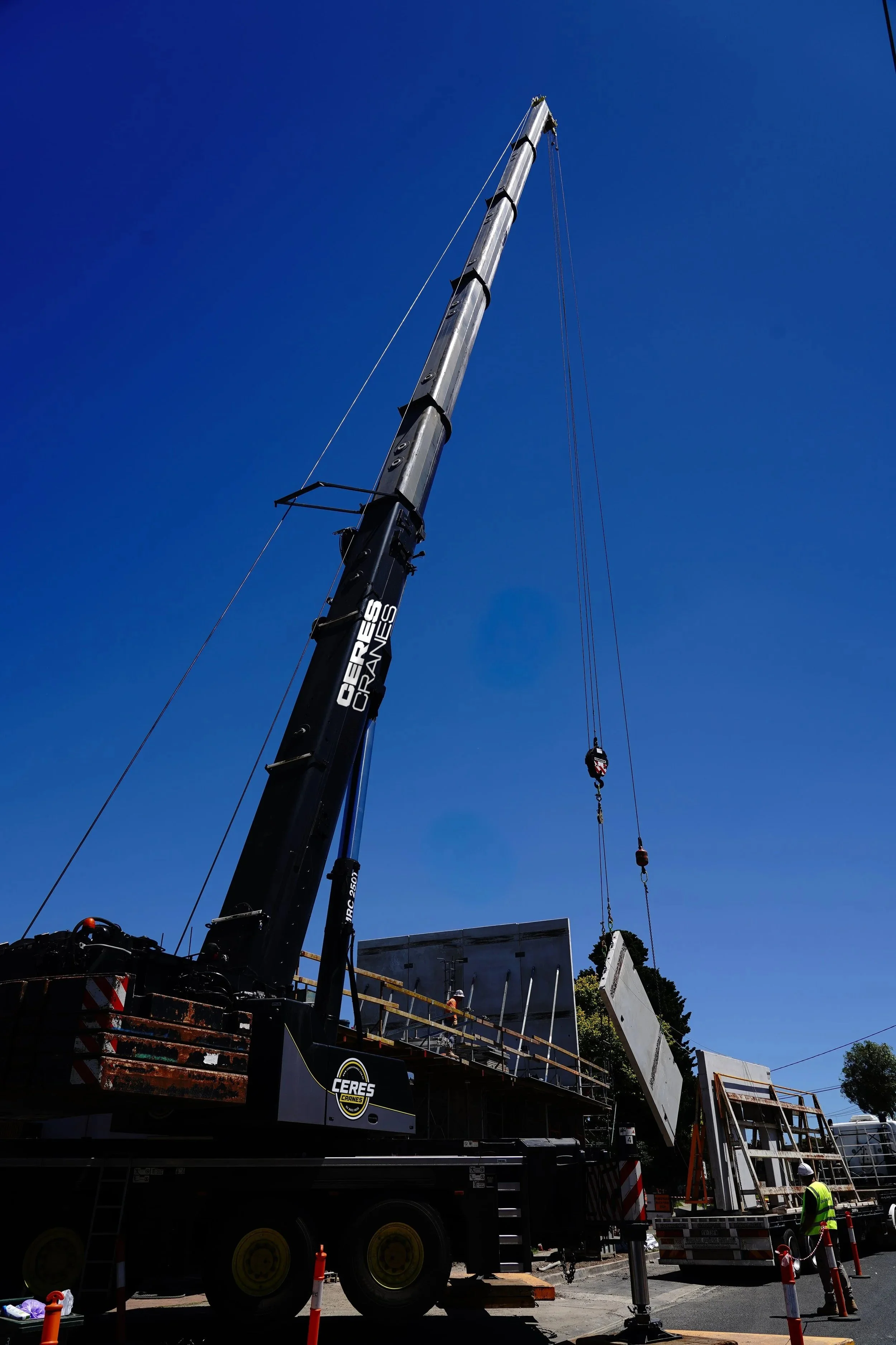 Ceres Cranes 250T Liebherr with long boom extended beside a building