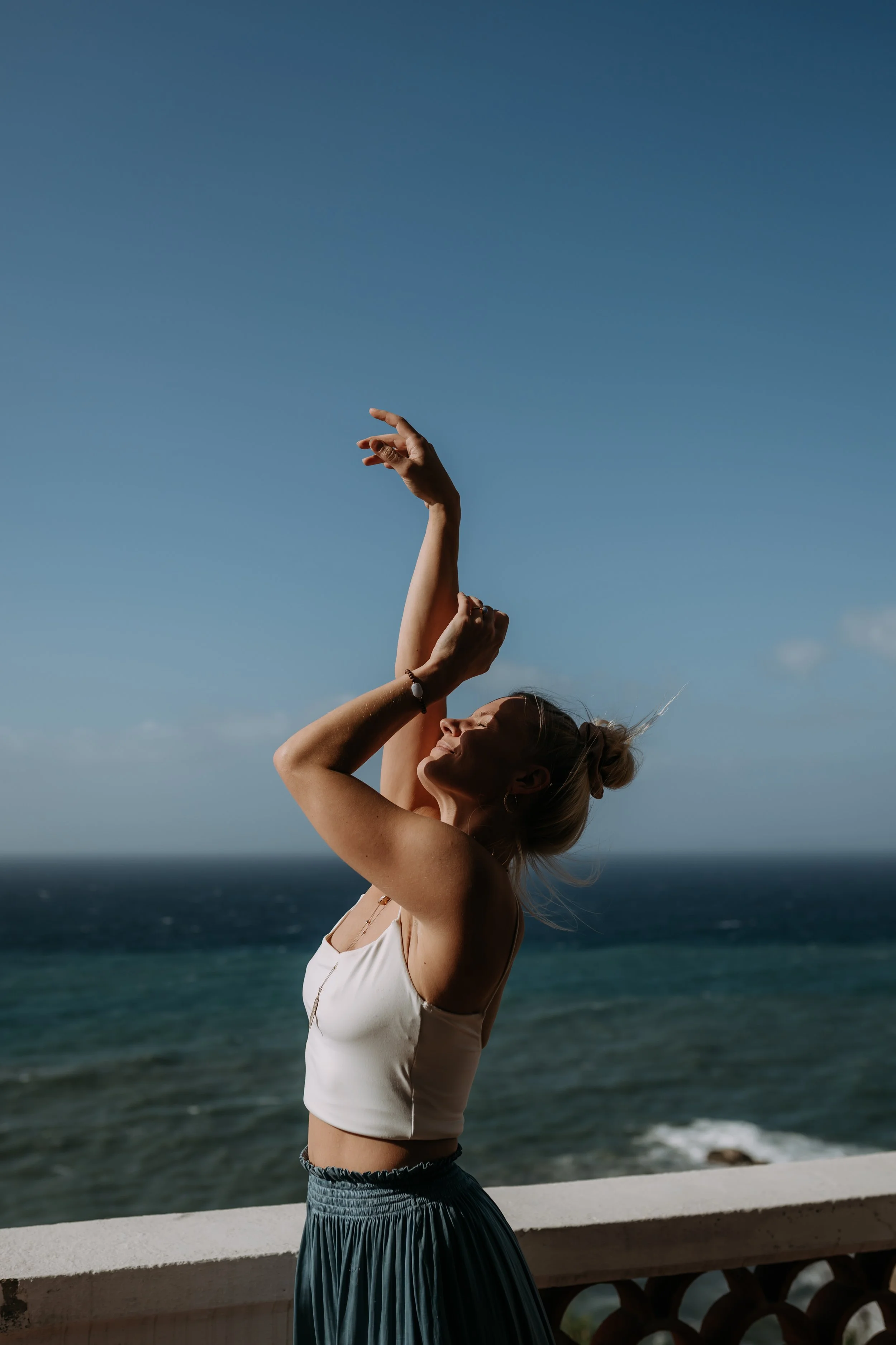 Iloinen nainen nauttii kehosta ja liikkeestä joogaretriitillä. 