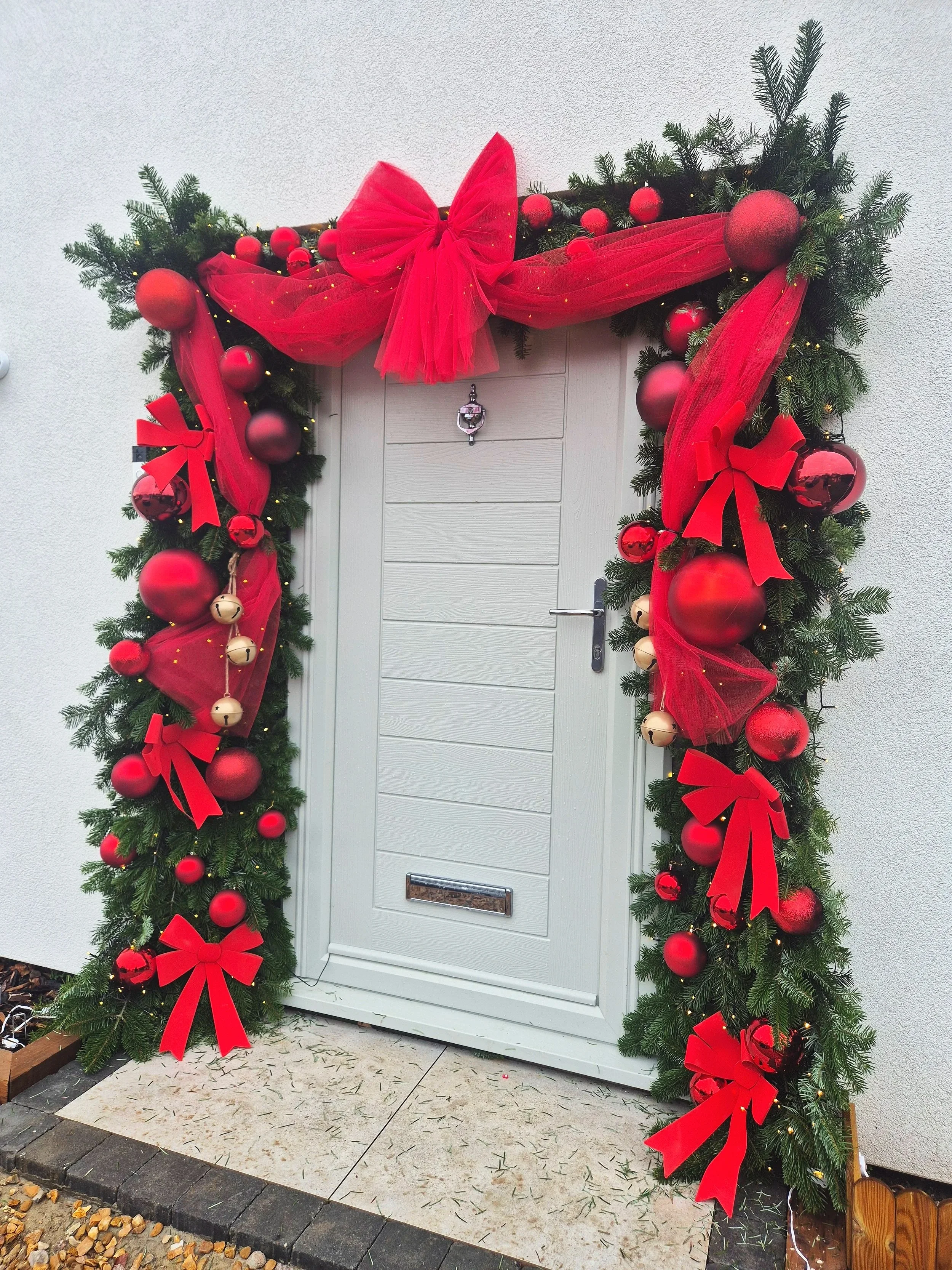 Christmas door styling using fresh spruce decorated in any colour this one is traditional red