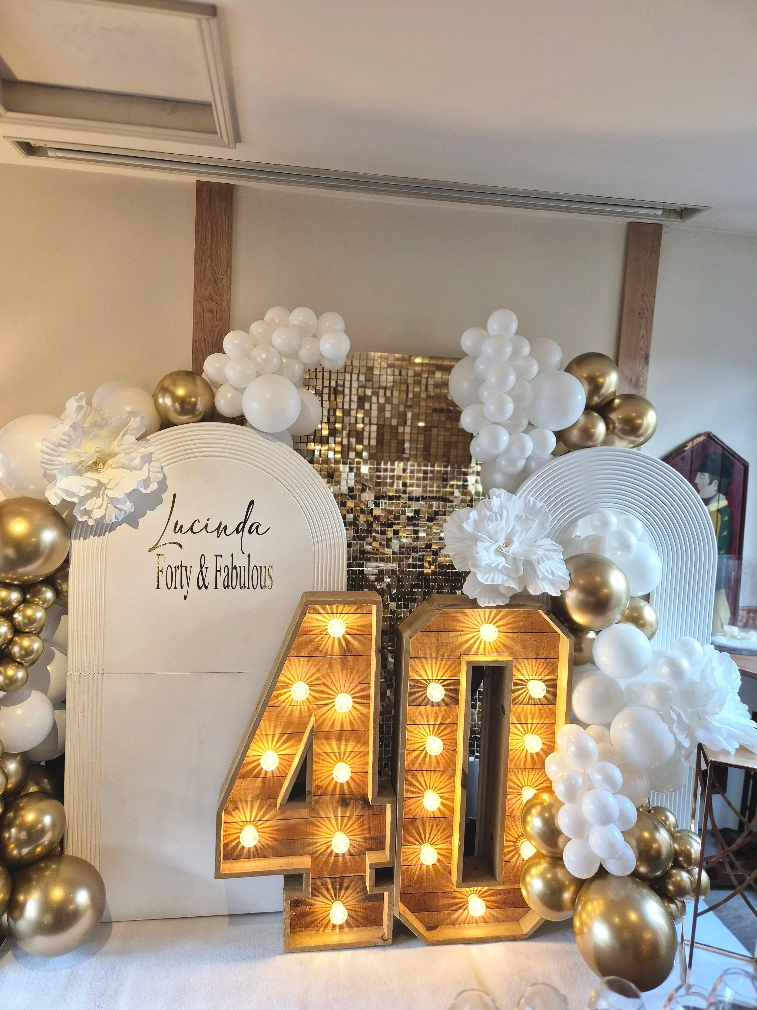 Light up 40 with sequin and sailboard backdrop with luxe balloon styling in white and Gold