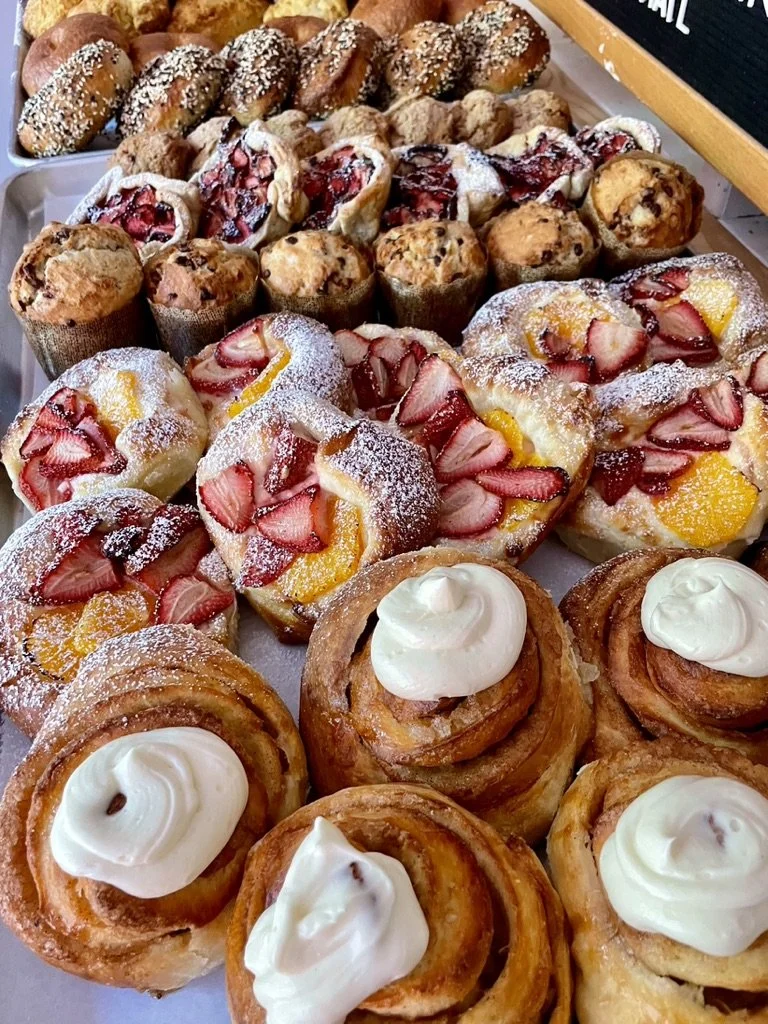 Assorted seasonal pastries including fruit danishes and cinnamon rolls from Colette Bread & Bakeshop