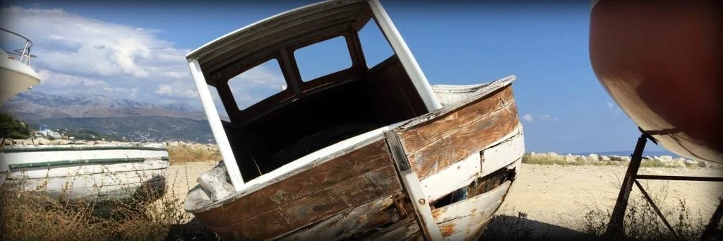 A small rusty shipwrecked boat on the beach