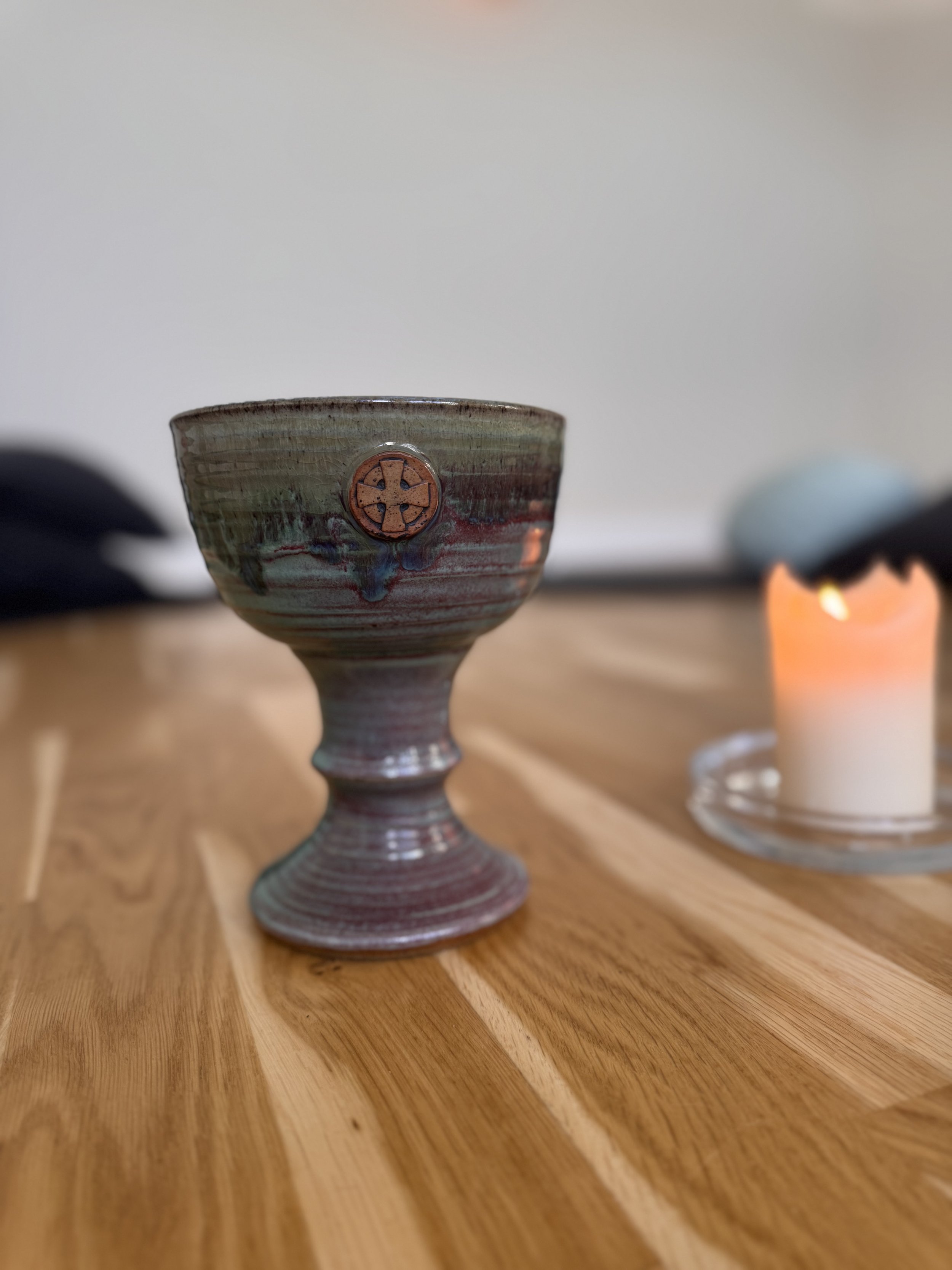 Den hellige gral og et brændende stearinlys på gulvet i Lysets Tempel