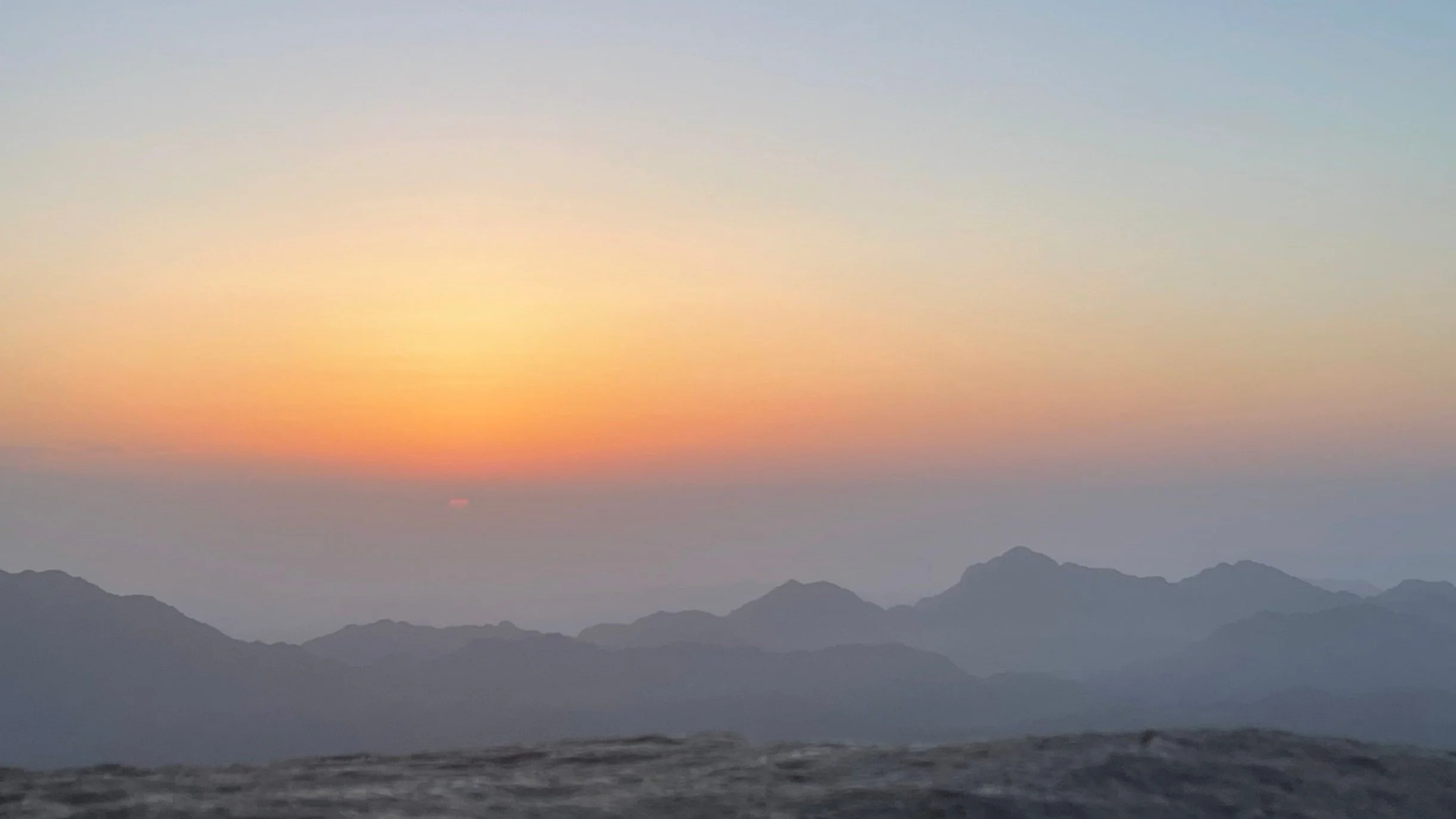 Solopgang over Sinai bjergene med orange himmel og mørke silhuetter af bjerge