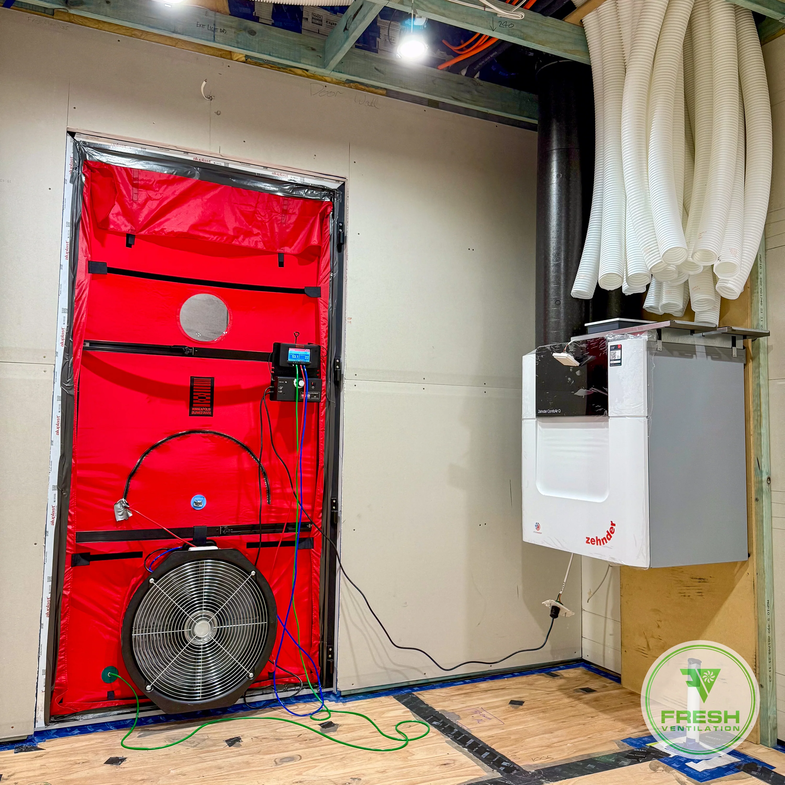 Blower door test setup measuring airtightness with mechanical ventilation system installed in residential home