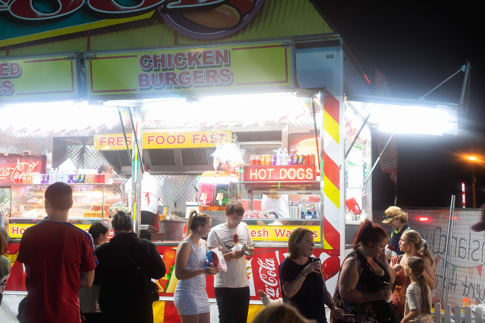 People purchasing food at a food van at a fair. 