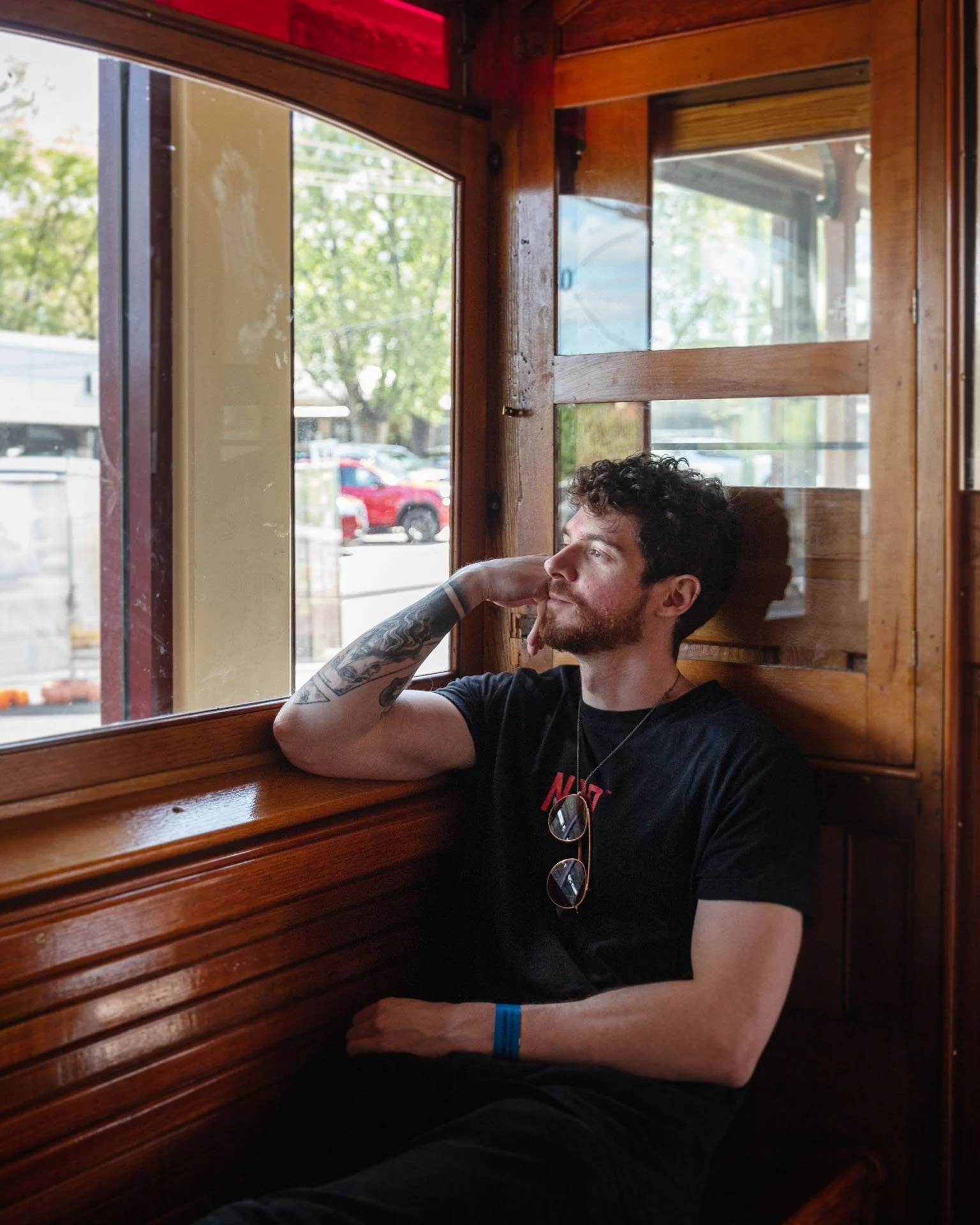  A photo of a man sitting by a window in an old tram. Photographed by Matthew Maguire.  