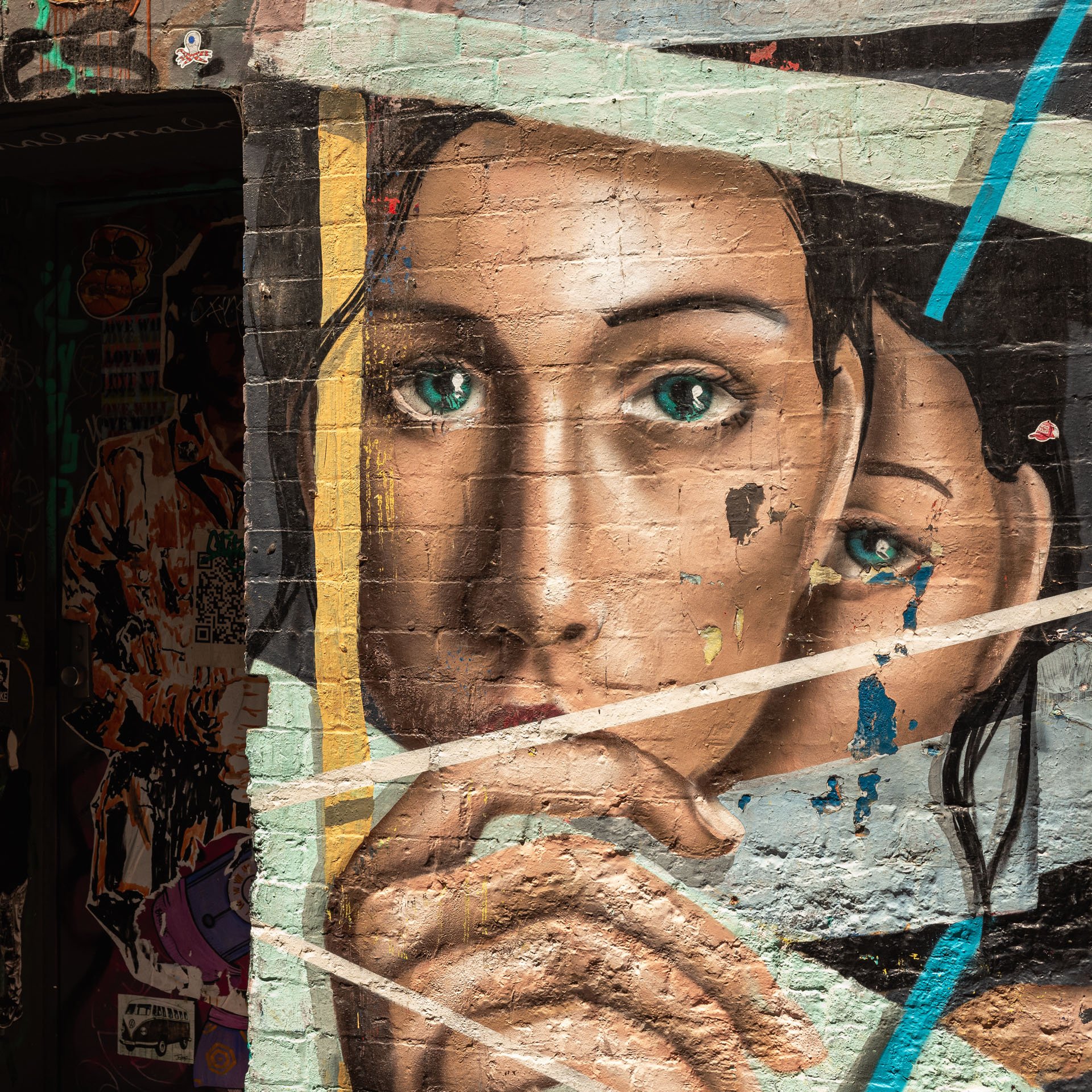  A photo of street art in ACDC lane in Melbourne’s CBD. The painting depicts 2 girls looking sombre staring at the viewer. 