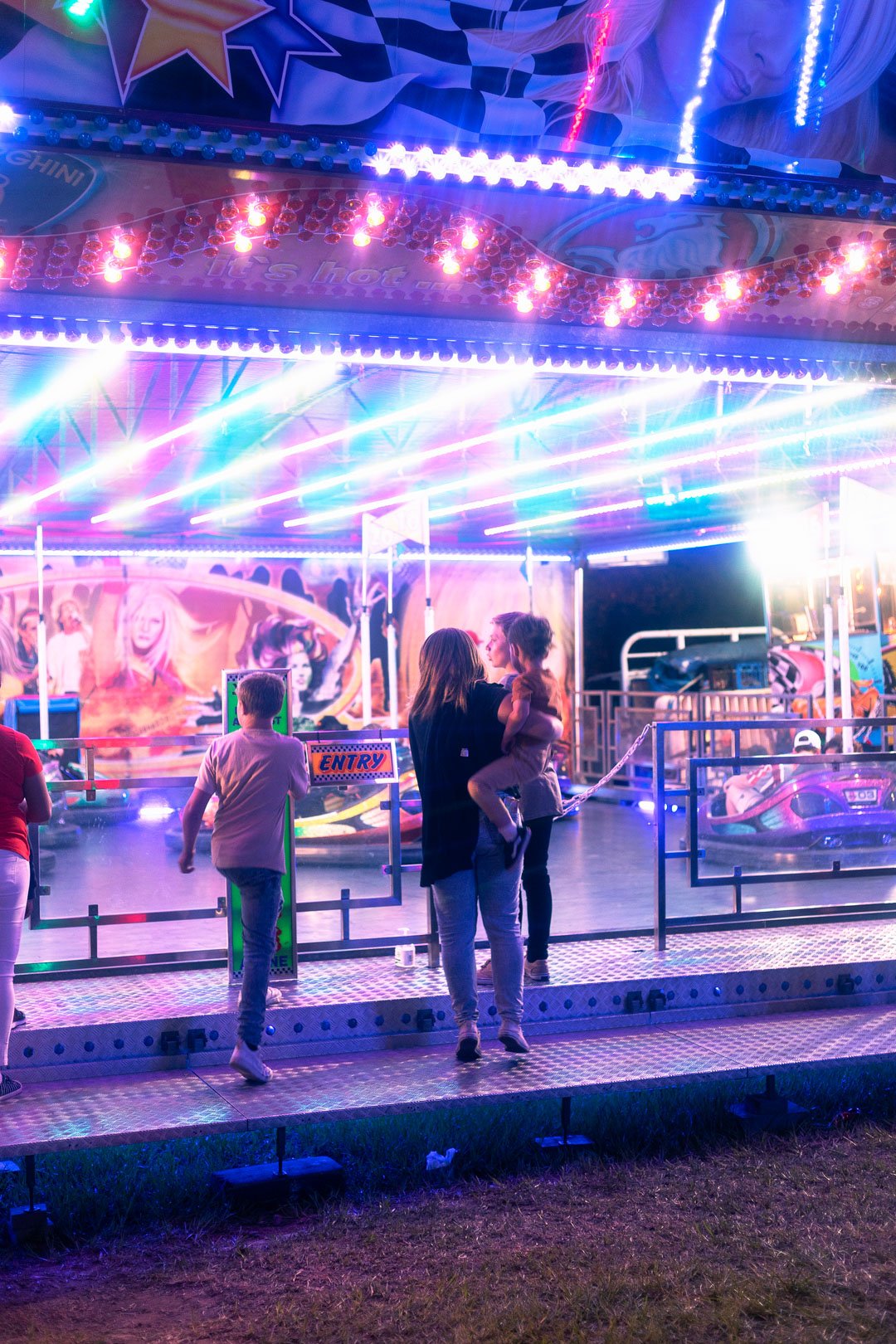 A family watching Bumper cars at night. 