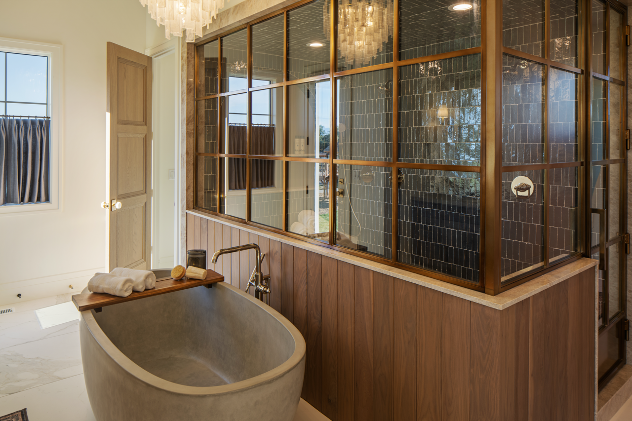 Modern bathroom with a freestanding bathtub, wooden accents, and a glass-enclosed shower with black tiles.