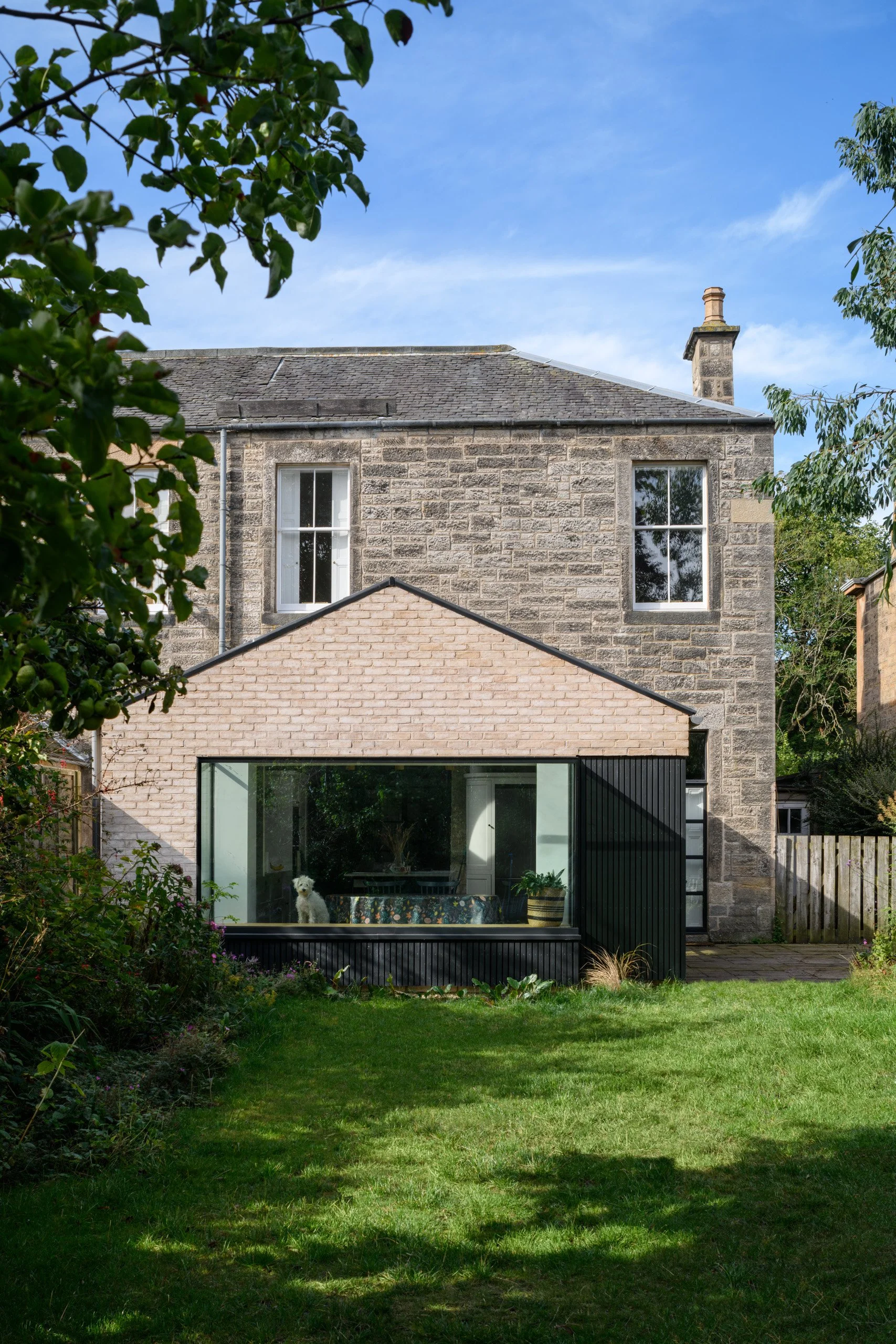 Stone house with large window extension and garden