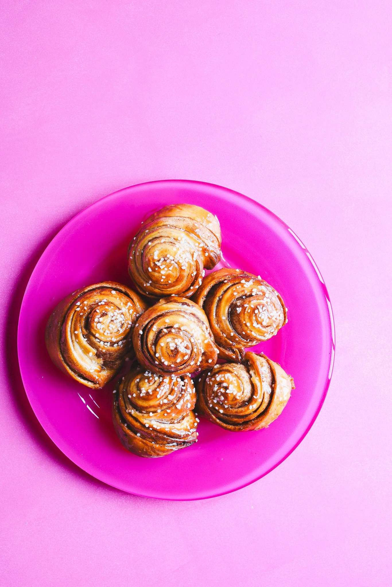 Cinnamon buns on a pink plate and background by food stylist and photographer, Louise Robinson, Cygnet Kitchen
