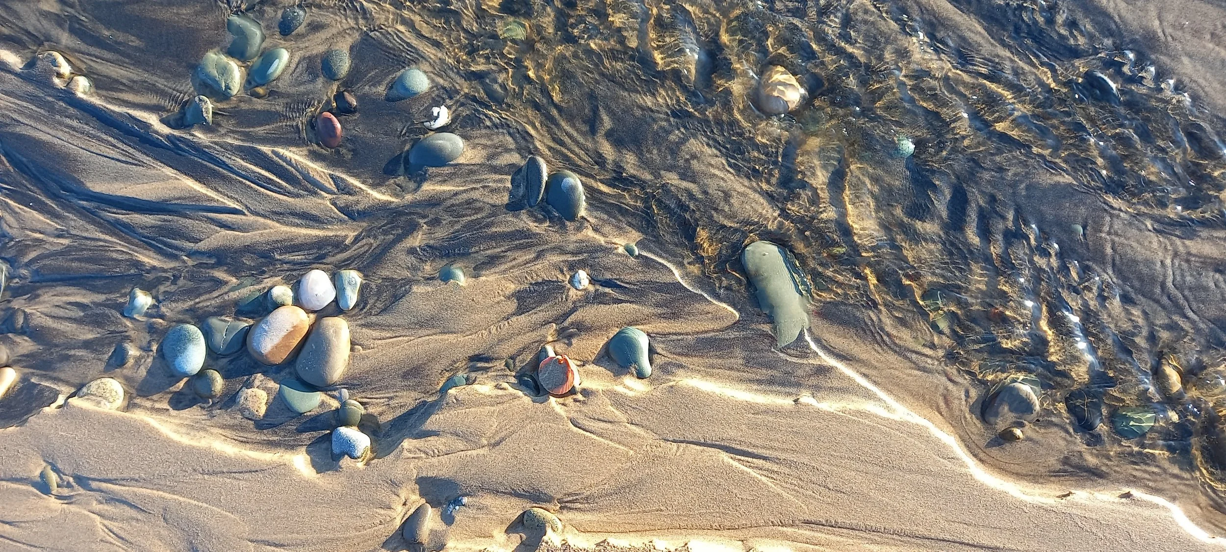Dried up trickling stream crosses the beach